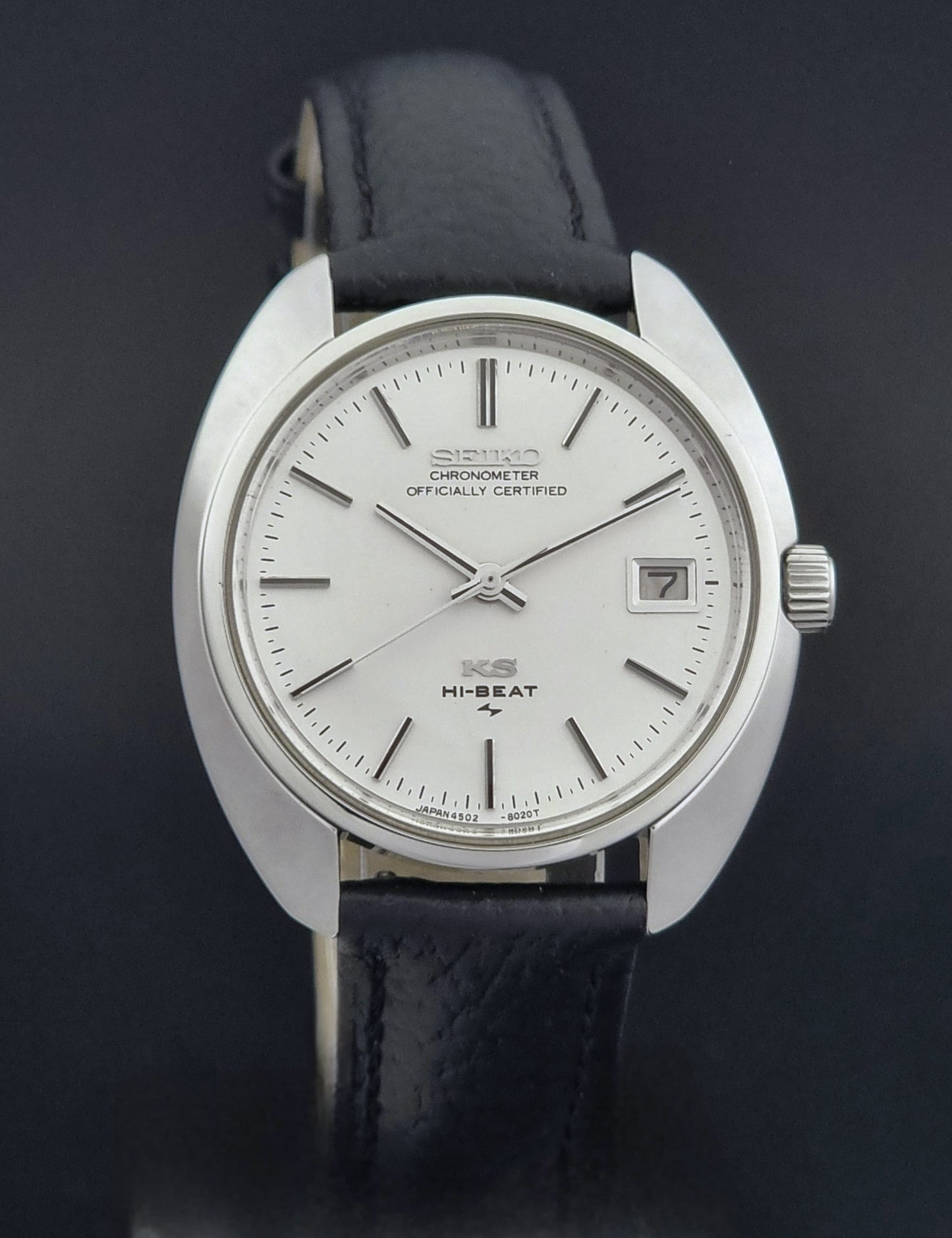 Vintage King Seiko Wristwatch 4502-8010 with black leather strap on a gray background close dial view