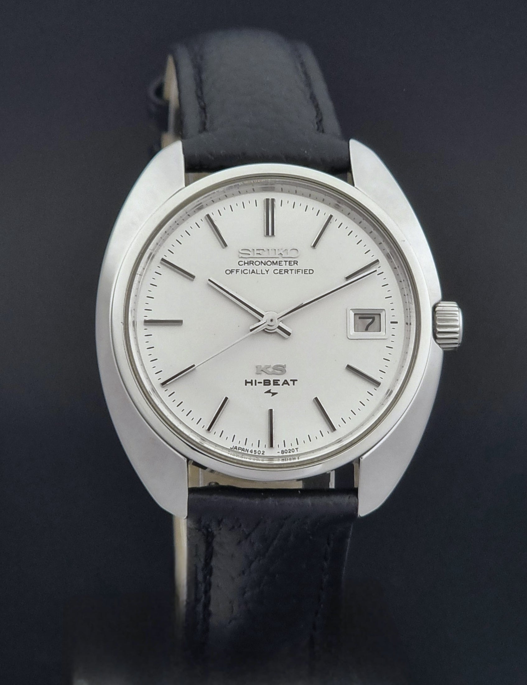 Vintage King Seiko Wristwatch 4502-8010 with black leather strap on a gray background close dial view