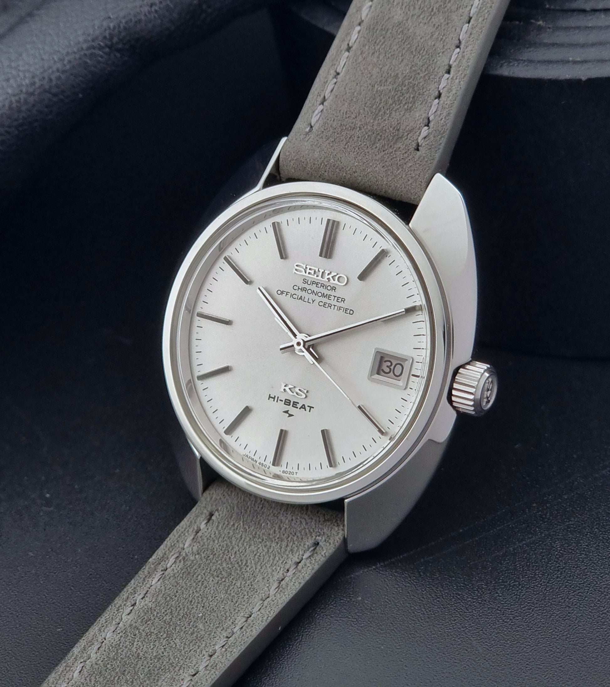 King Seiko Watch Hi-Beat 4502-8010 with gray strap and silver dial on a dark background crown side view