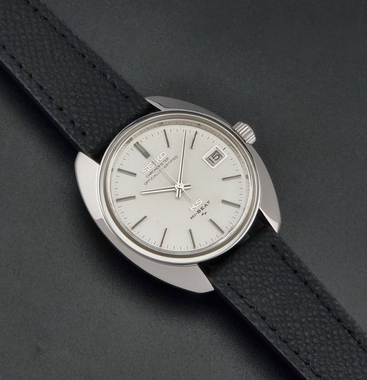 Vintage King Seiko Wristwatch 4502-8010 with a silver-toned metal case, white dial, and black textured leather strap, on a dark background dial
