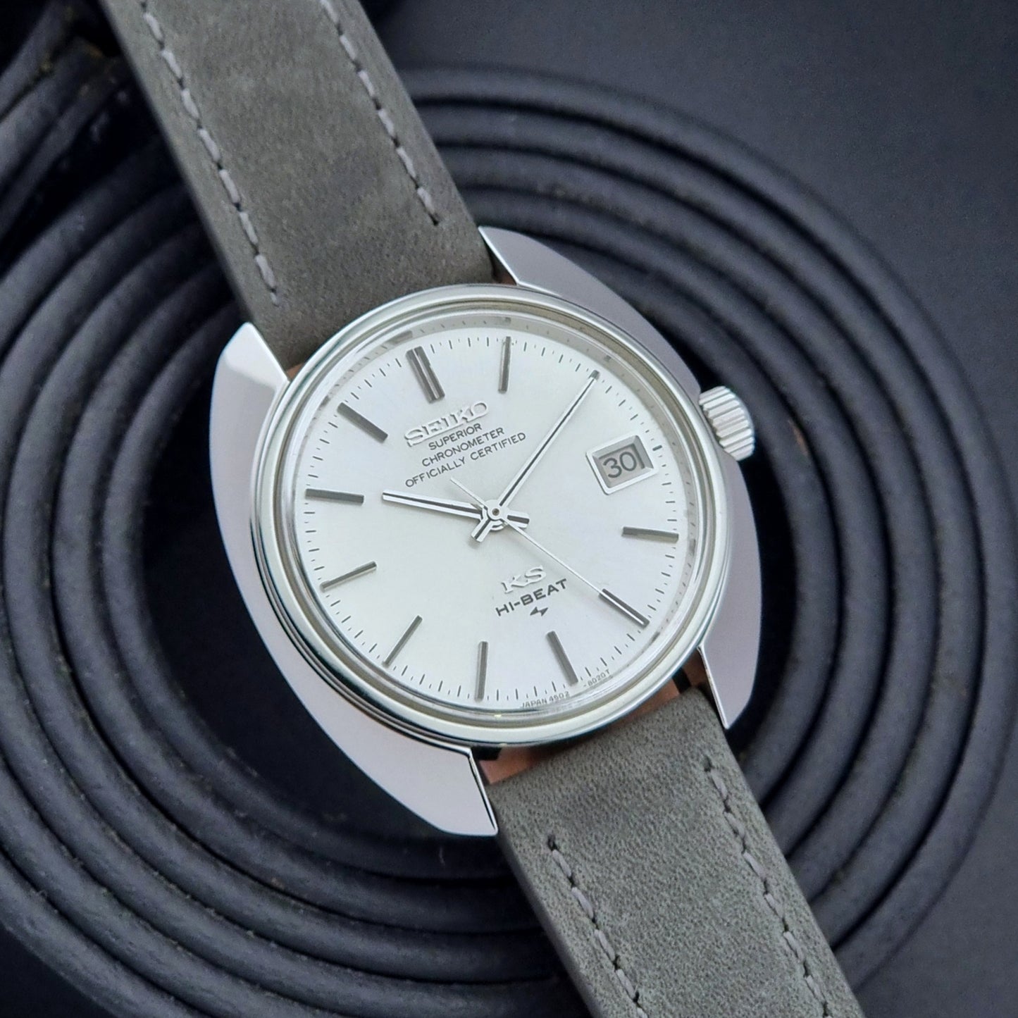 King Seiko Watch Hi-Beat 4502-8010 with gray strap and silver dial on a dark background jaunty front view