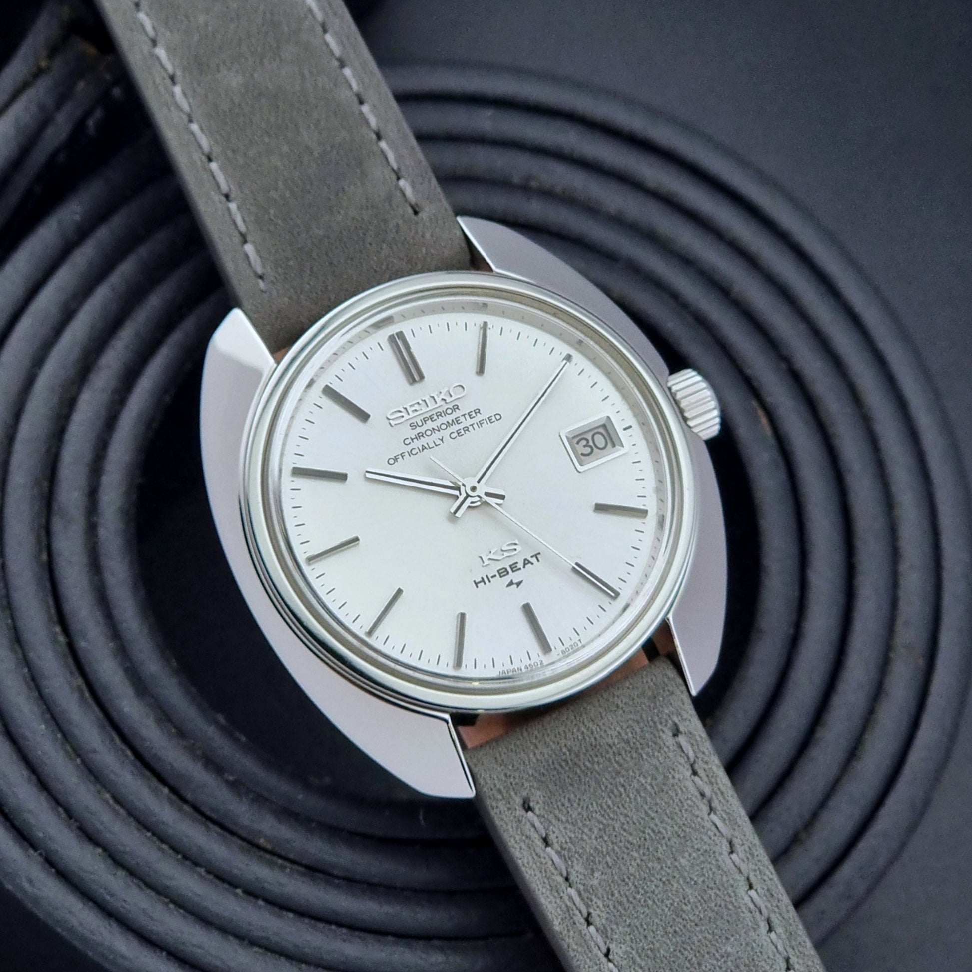 King Seiko Watch Hi-Beat 4502-8010 with gray strap and silver dial on a dark background jaunty front view