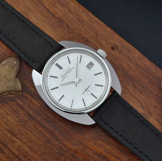 Vintage King Seiko Wristwatch 4502-8010 with black leather strap and silver case on a wooden background front