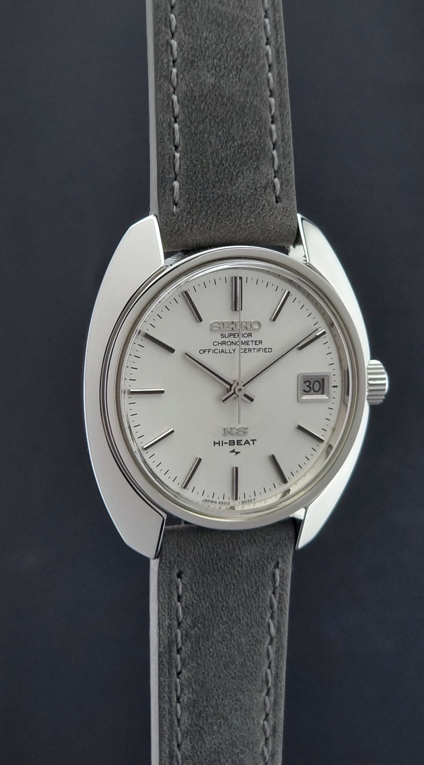 King Seiko Watch Hi-Beat 4502-8010 with gray strap and silver dial on a dark background side profile