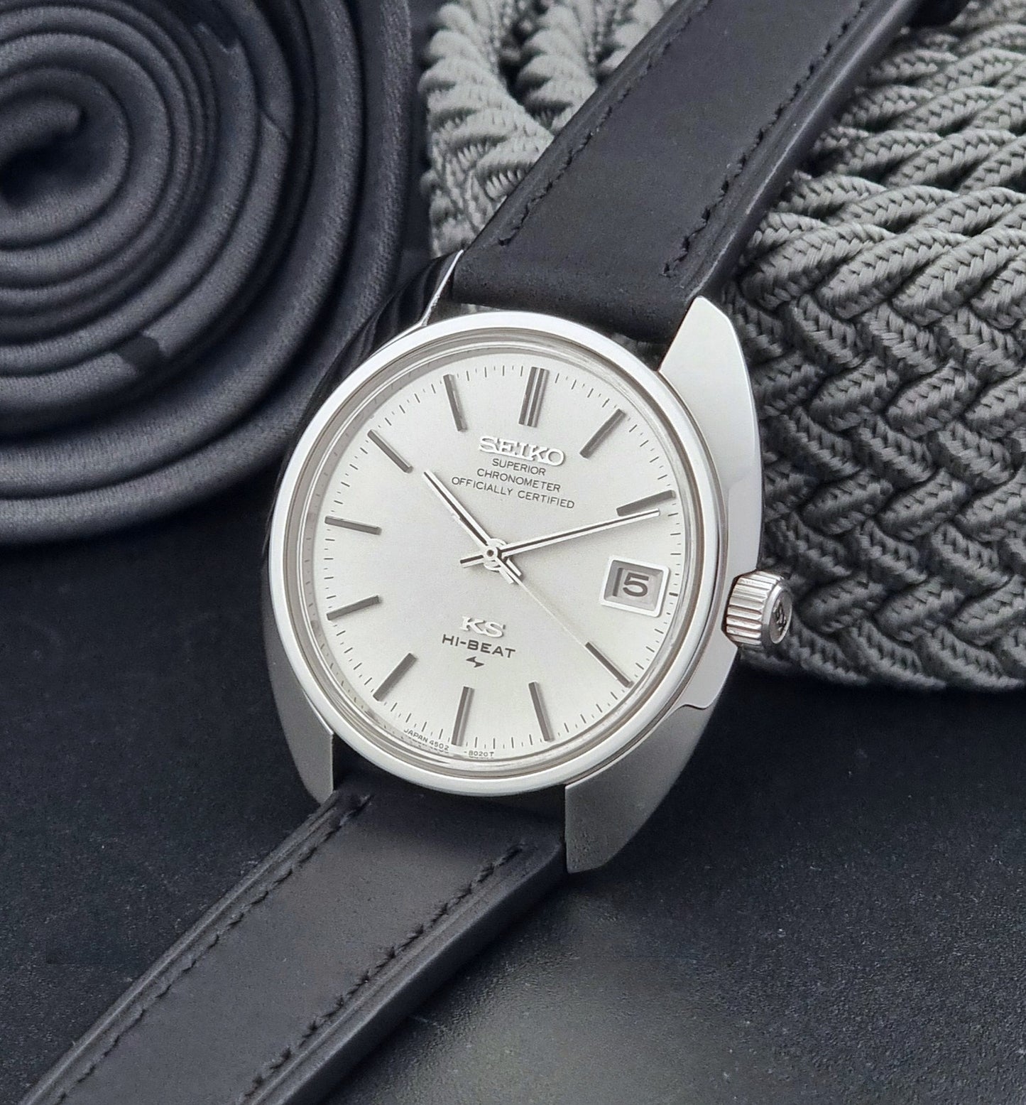 Vintage King Seiko Watch 4502-8010 with a black leather strap on a dark background crown view