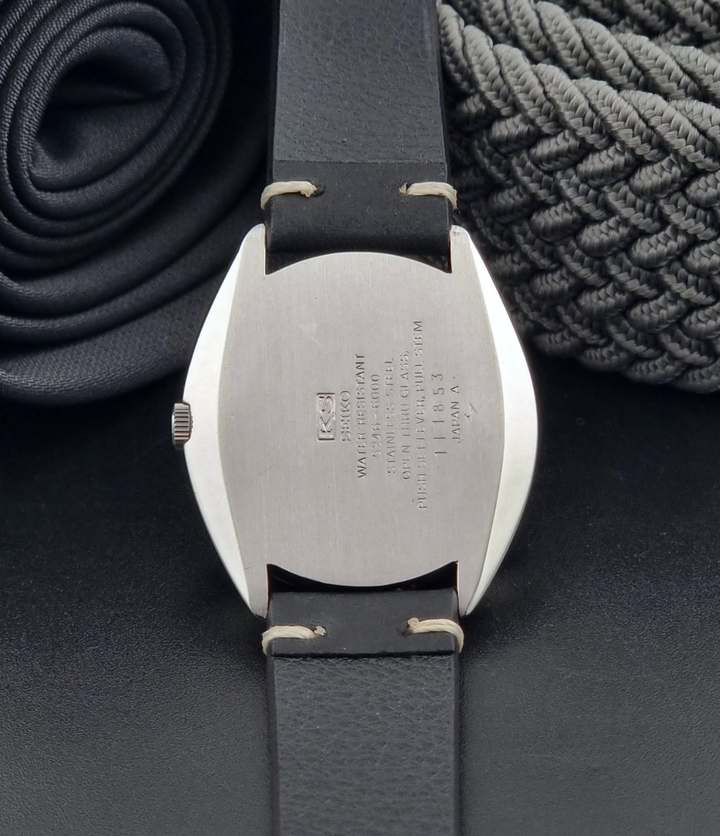 Vintage King Seiko Watch Special 5246-6000 with black leather strap on a dark gray background case back view