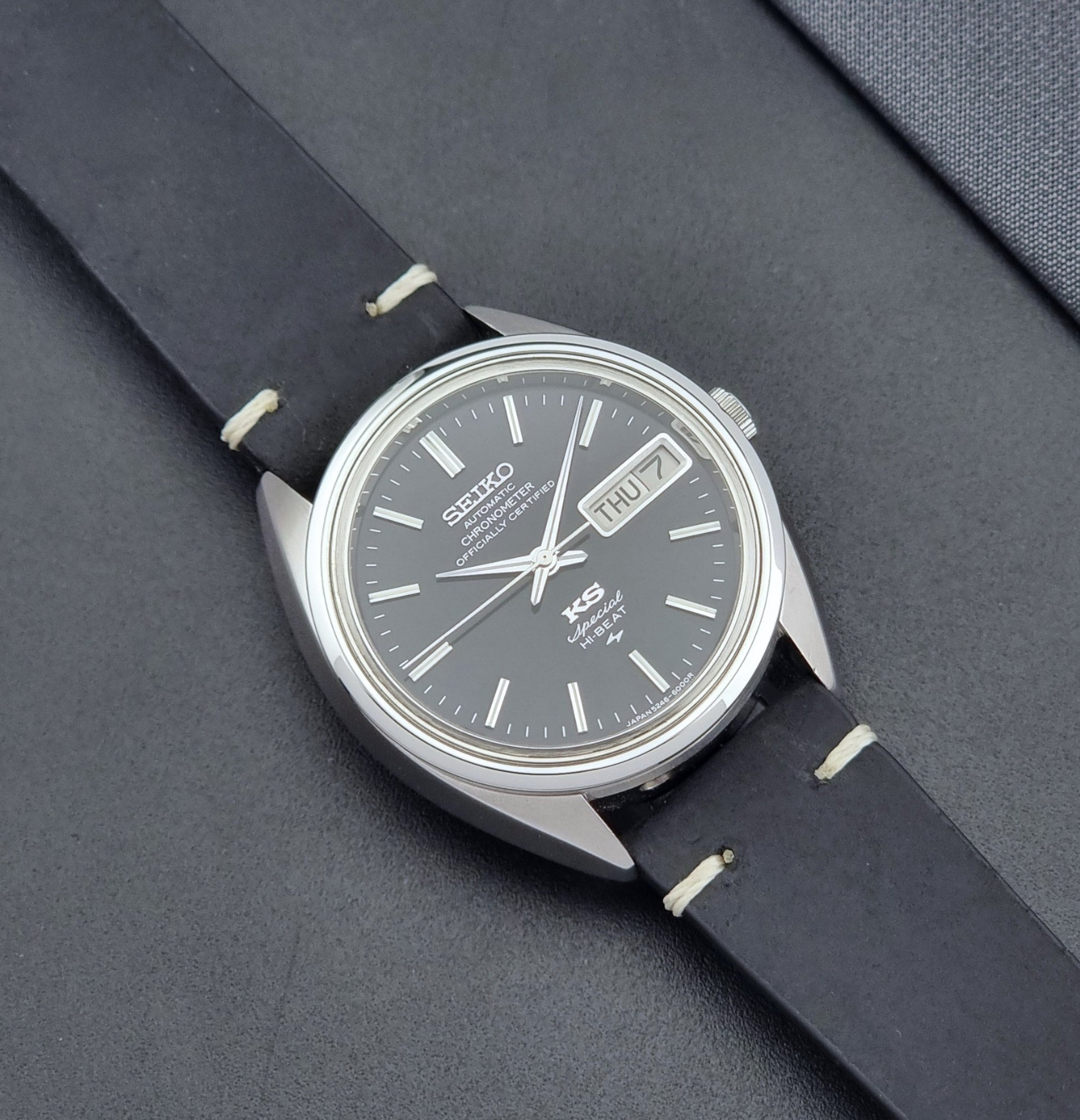 Vintage King Seiko Watch Special 5246-6000 with black leather strap on a dark gray background close up dial view