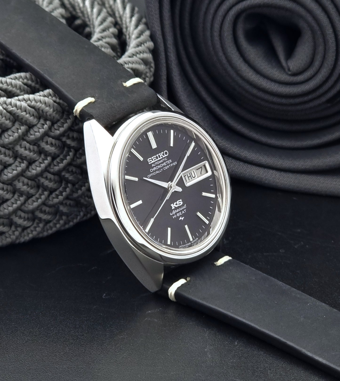 Vintage King Seiko Watch Special 5246-6000 with black leather strap on a dark gray background side view