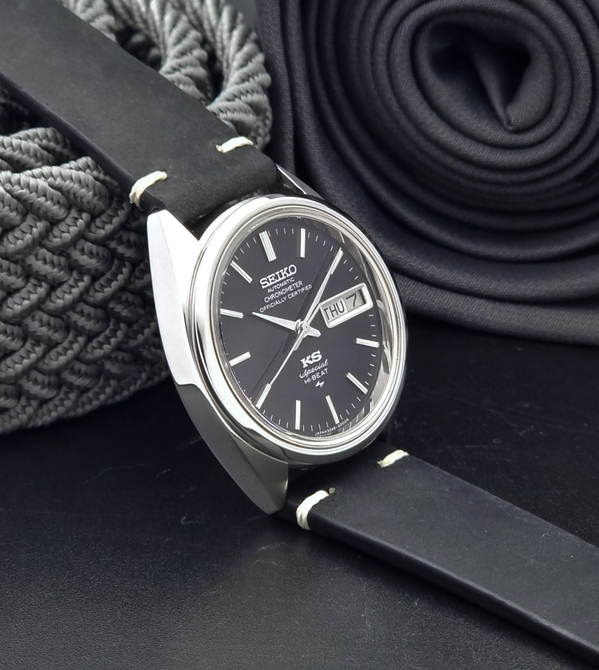 Vintage King Seiko Watch Special 5246-6000 with black leather strap on a dark gray background side view