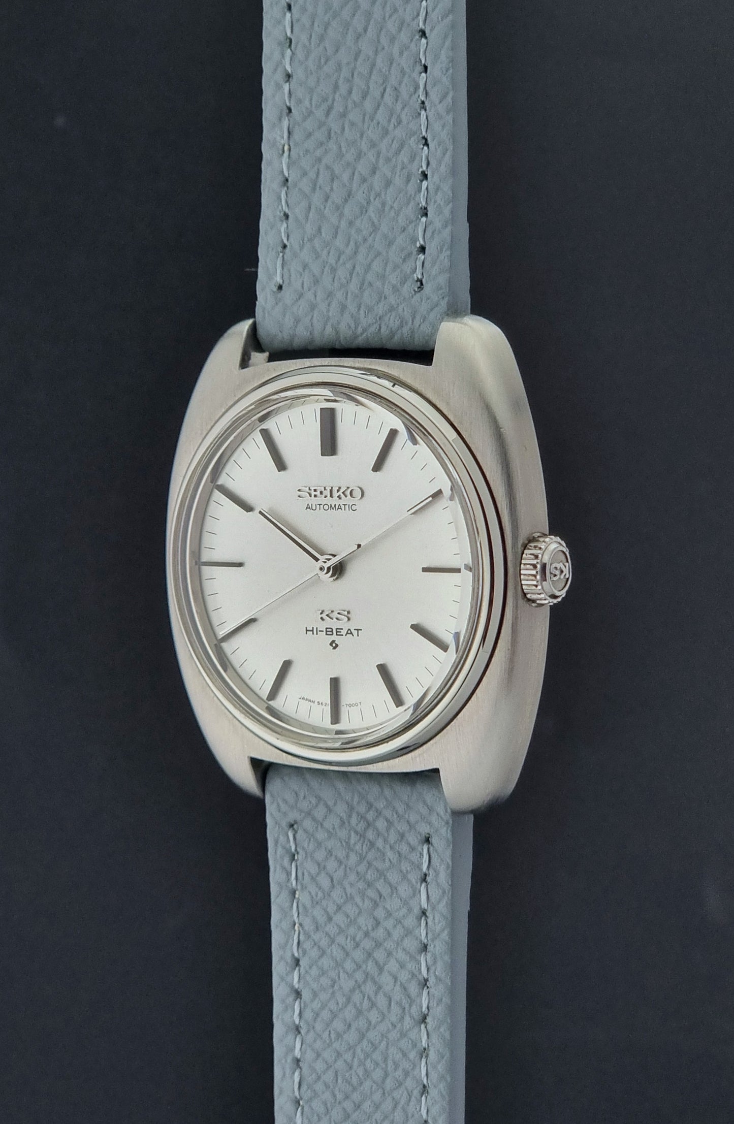Vintage King Seiko Wristwatch 5621-7000 with light grey leather strap on a dark gray background crown profile view