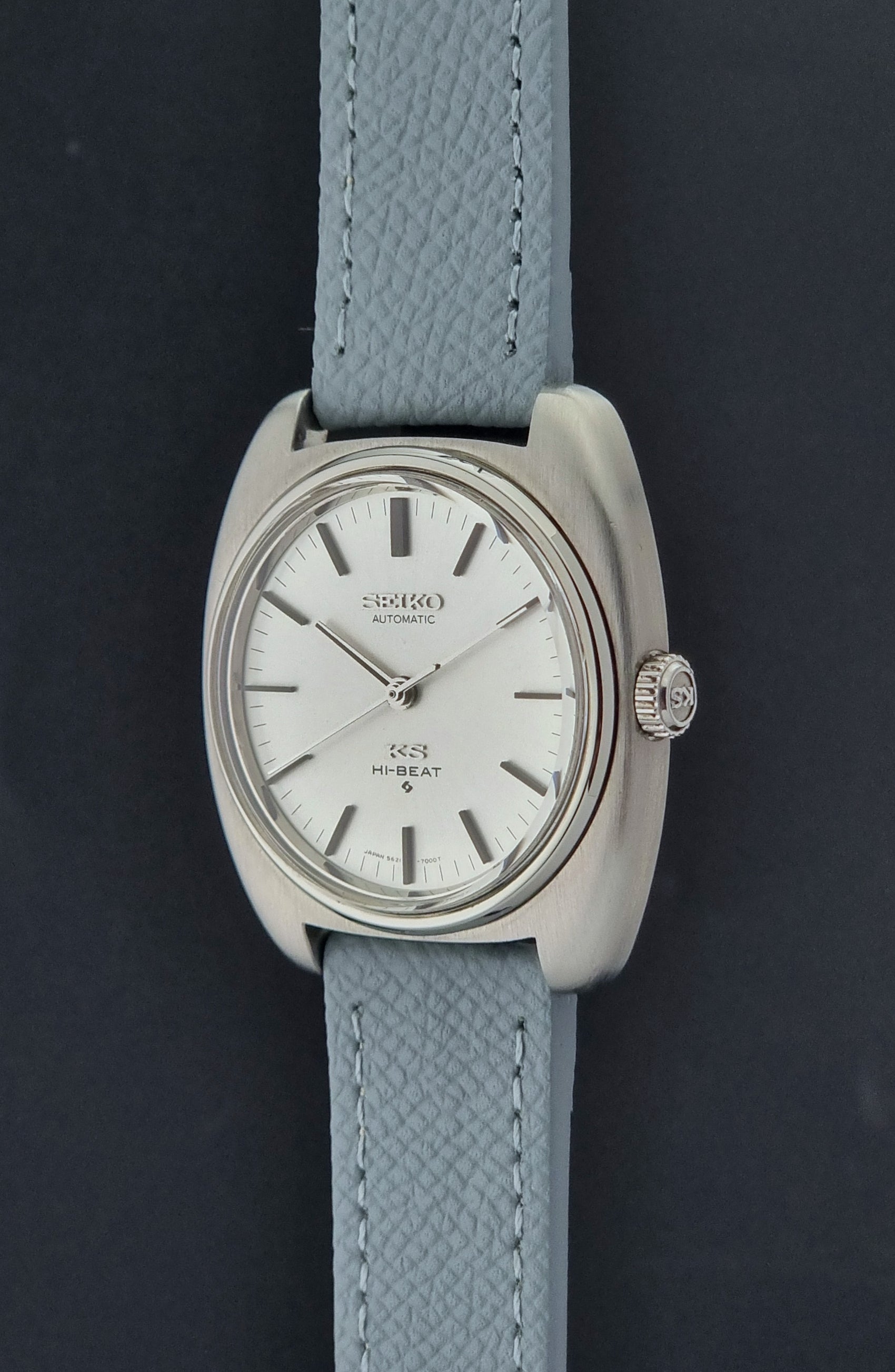 Vintage King Seiko Wristwatch 5621-7000 with light grey leather strap on a dark gray background crown profile view