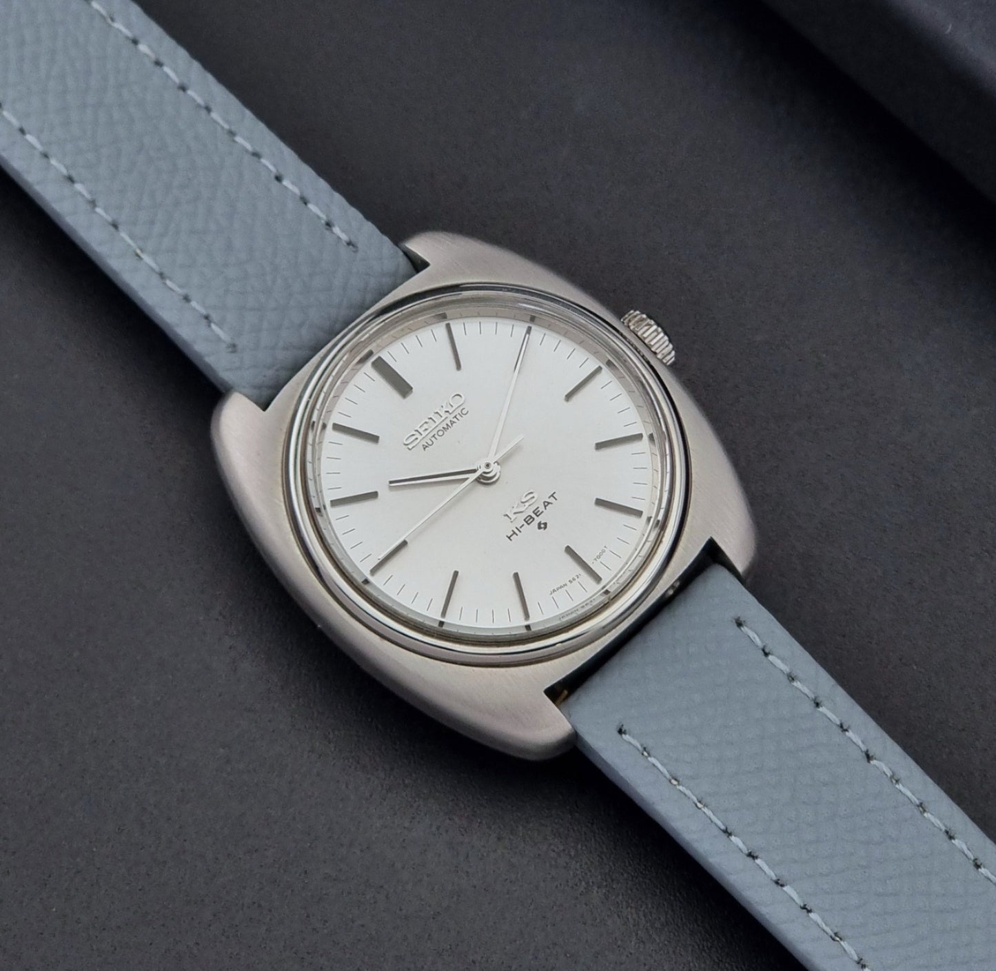 Vintage King Seiko Wristwatch 5621-7000 with light grey leather strap on a dark gray background close up dial view