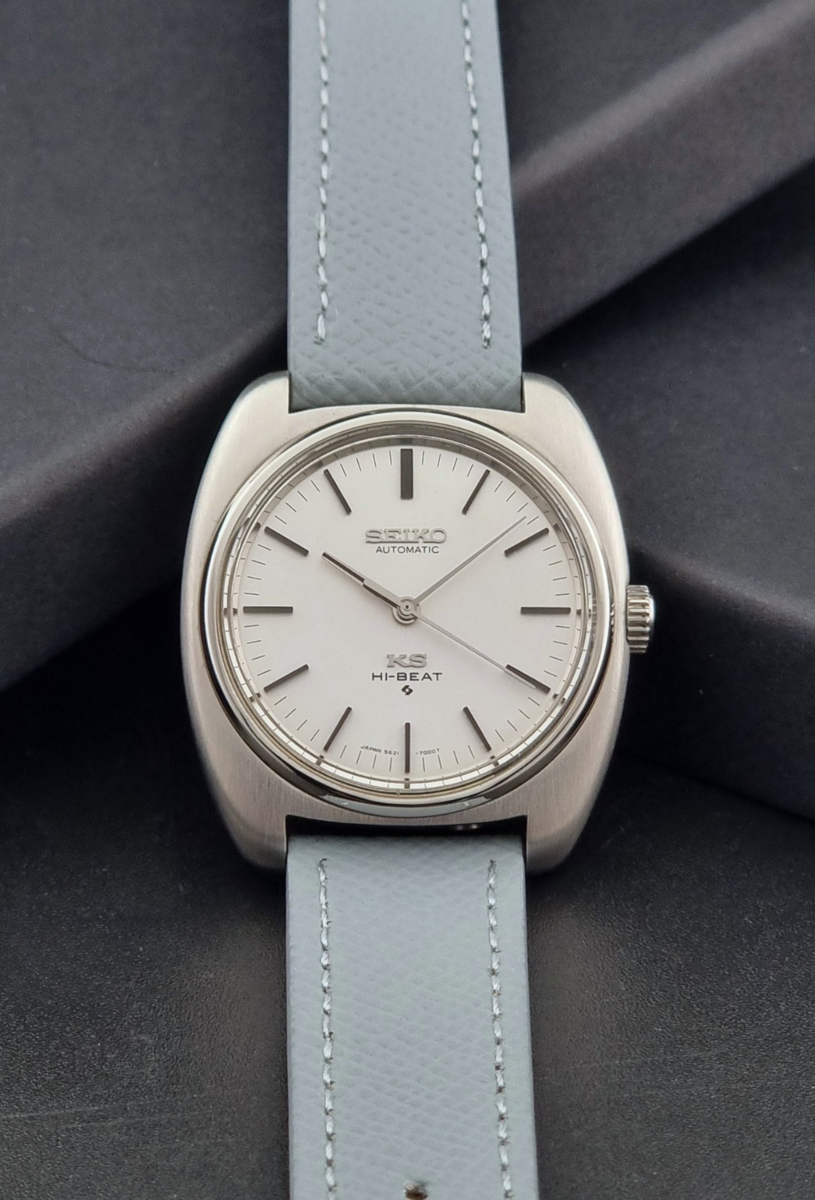 Vintage King Seiko Wristwatch 5621-7000 with light grey leather strap on a dark gray background dial view