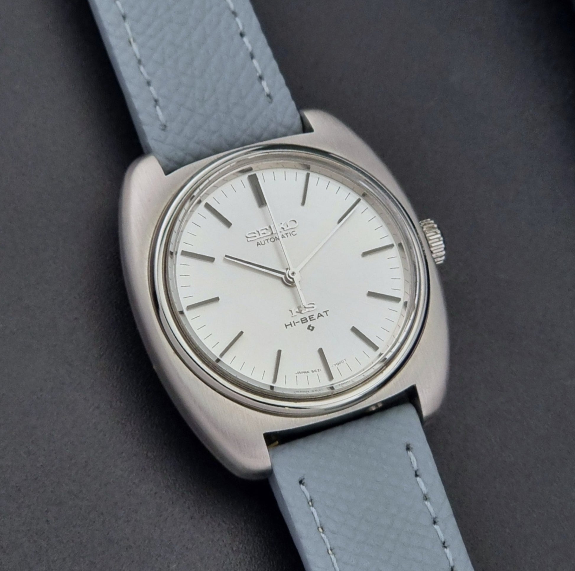 Vintage King Seiko Wristwatch 5621-7000 with light grey leather strap on a dark gray background front view