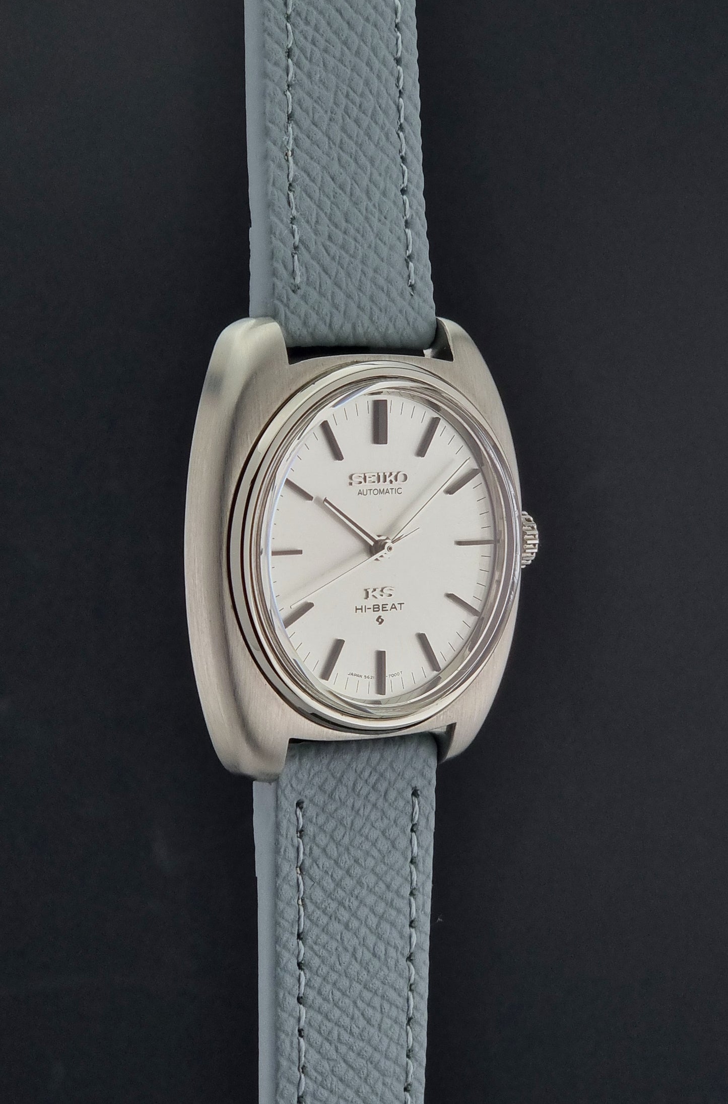Vintage King Seiko Wristwatch 5621-7000 with light grey leather strap on a dark gray background side profile view