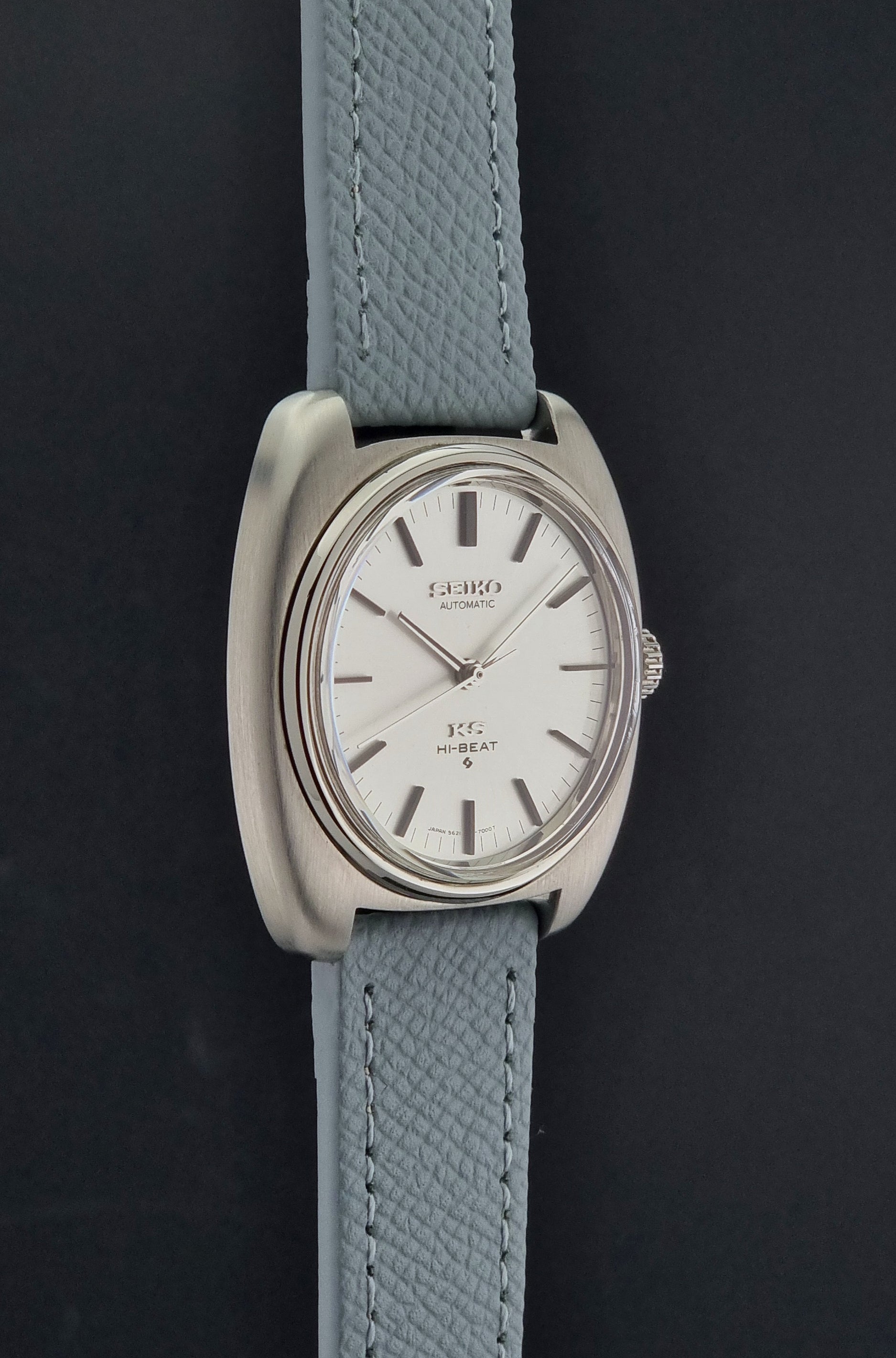 Vintage King Seiko Wristwatch 5621-7000 with light grey leather strap on a dark gray background side profile view
