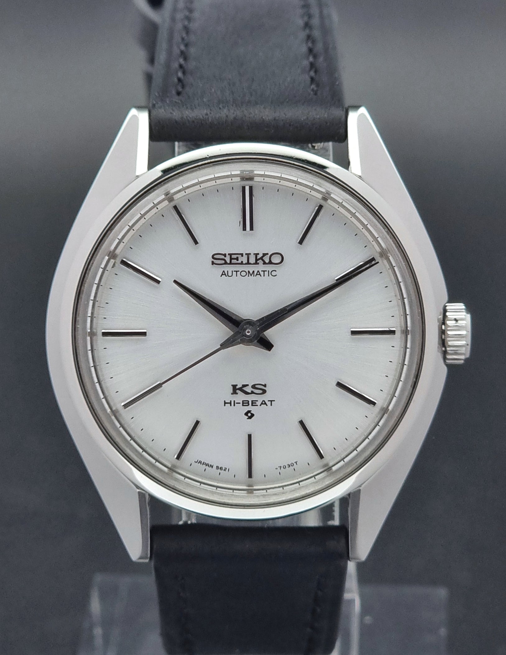 King Seiko watch with black leather strap on a reflective surface
