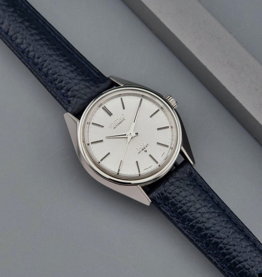 Vintage King Seiko Wristwatch 5621-7020with a blue leather strap on a gray background front