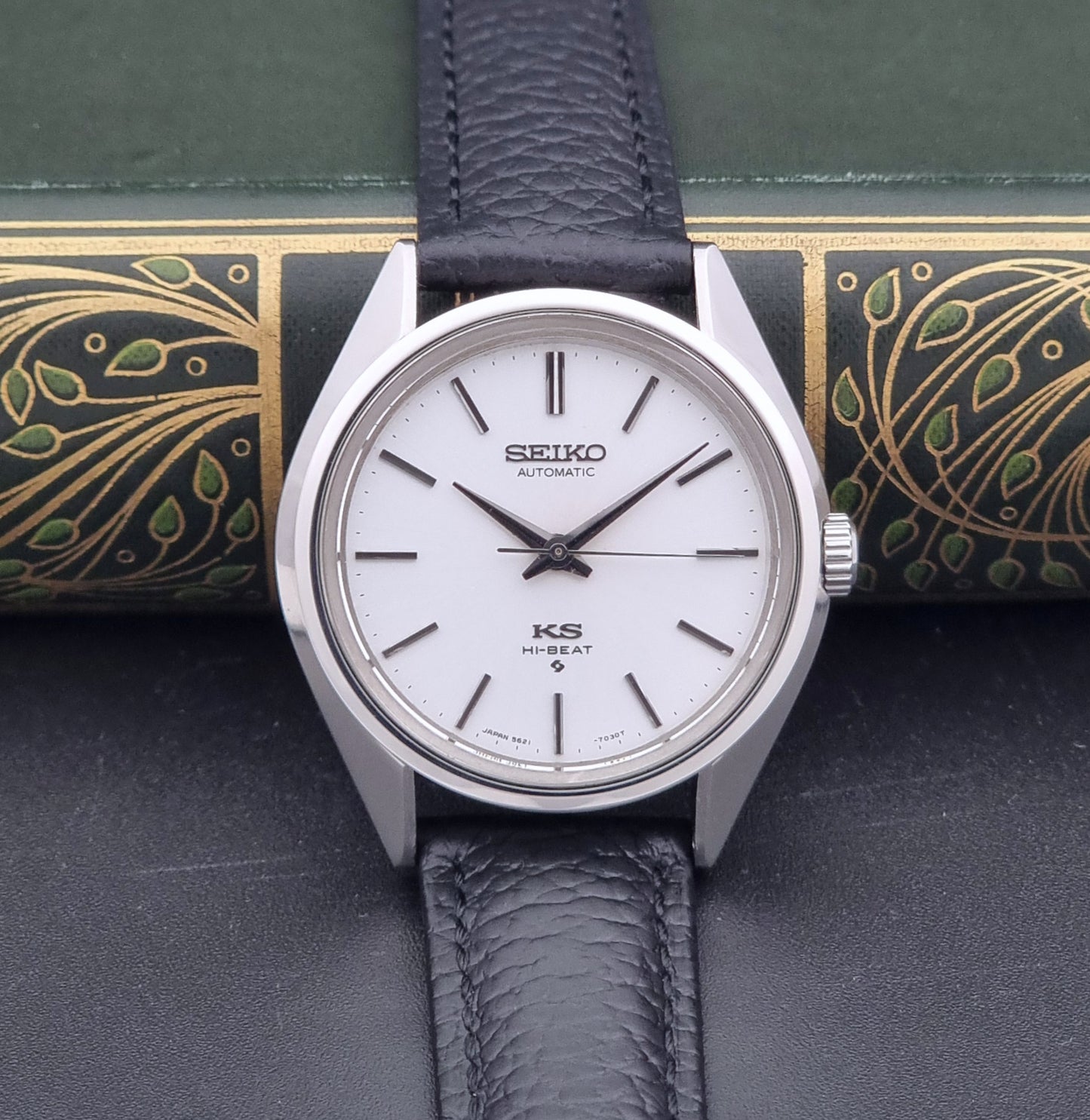 Vintage King Seiko Wristwatch 5621-7022 with a dark leather strap on a green background dial view