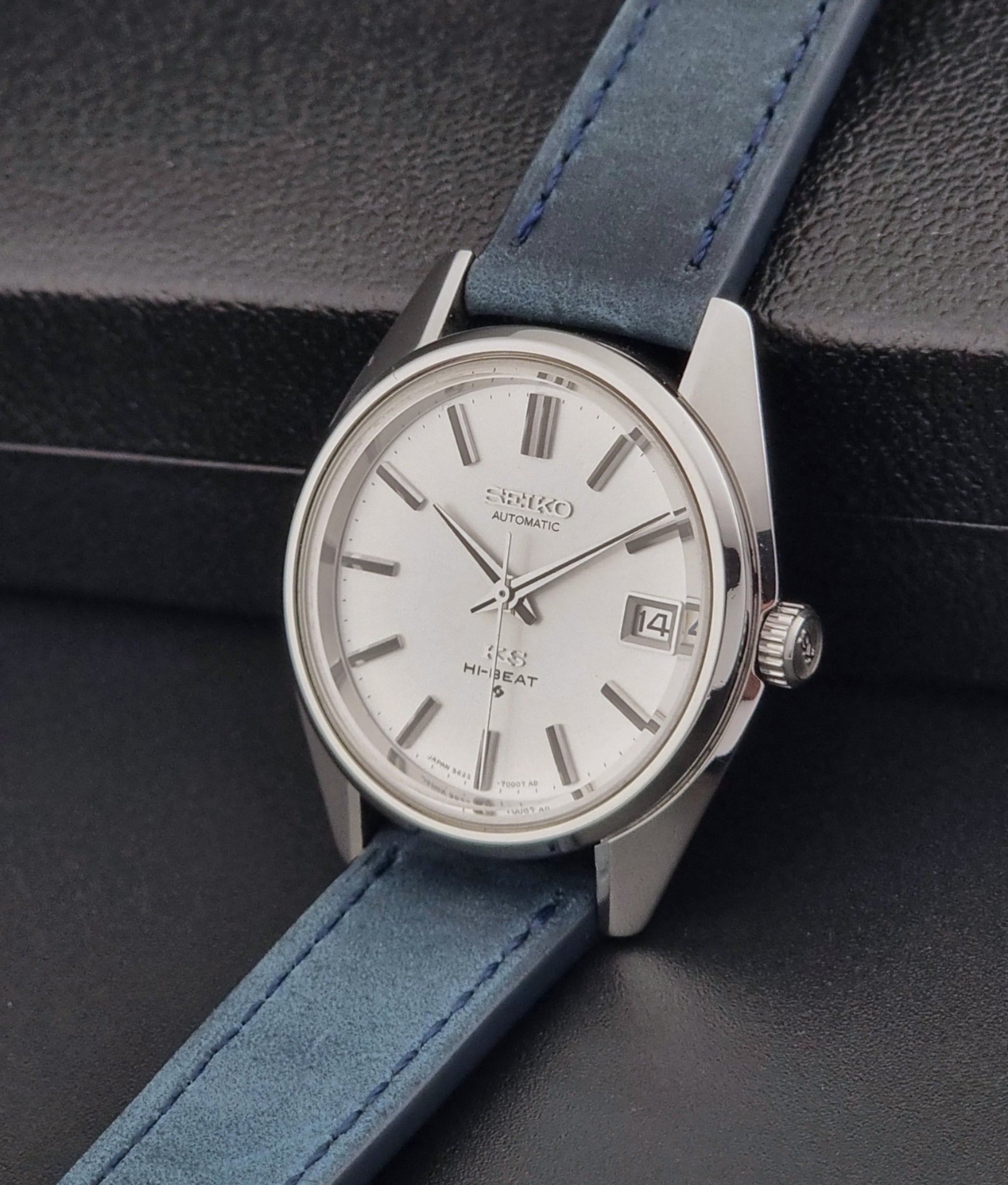 Vintage King Seiko 5625-7000 Wristwatch with blue strap and silver case on a dark textured background
