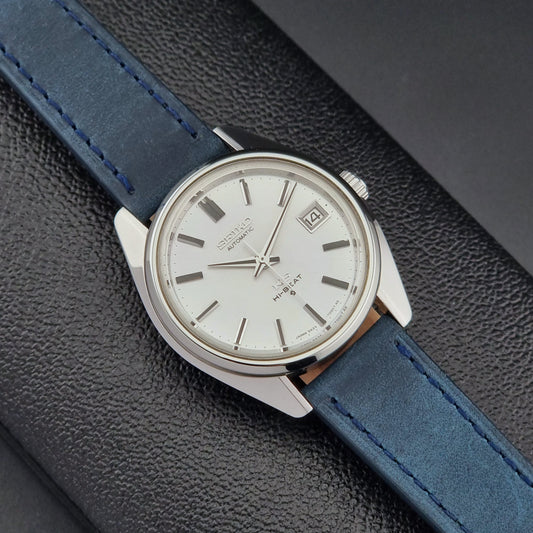 Vintage King Seiko 5625-7000 Wristwatch with blue strap and silver case on a dark textured background