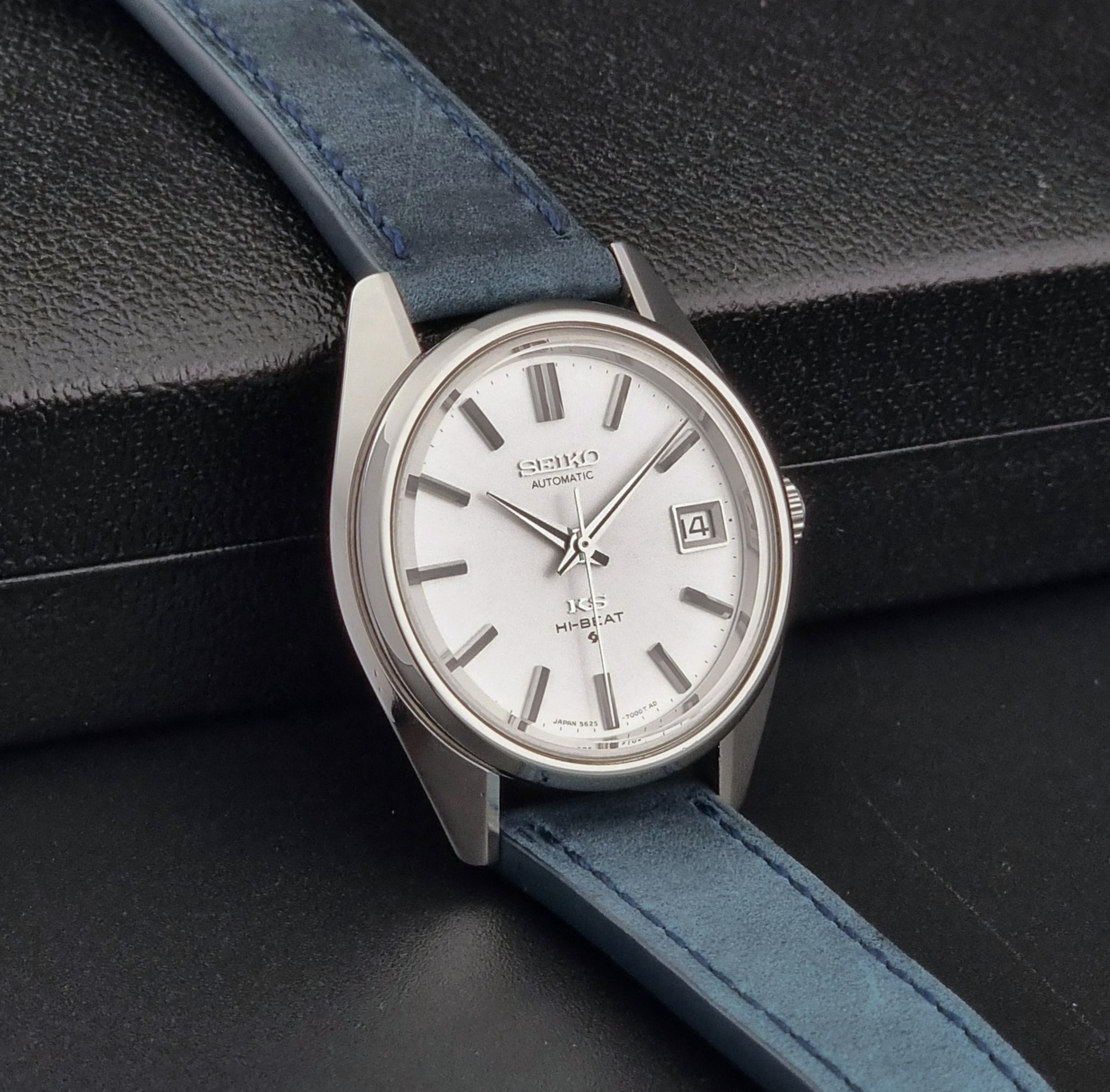 Vintage King Seiko 5625-7000 Wristwatch with blue strap and silver case on a dark textured background