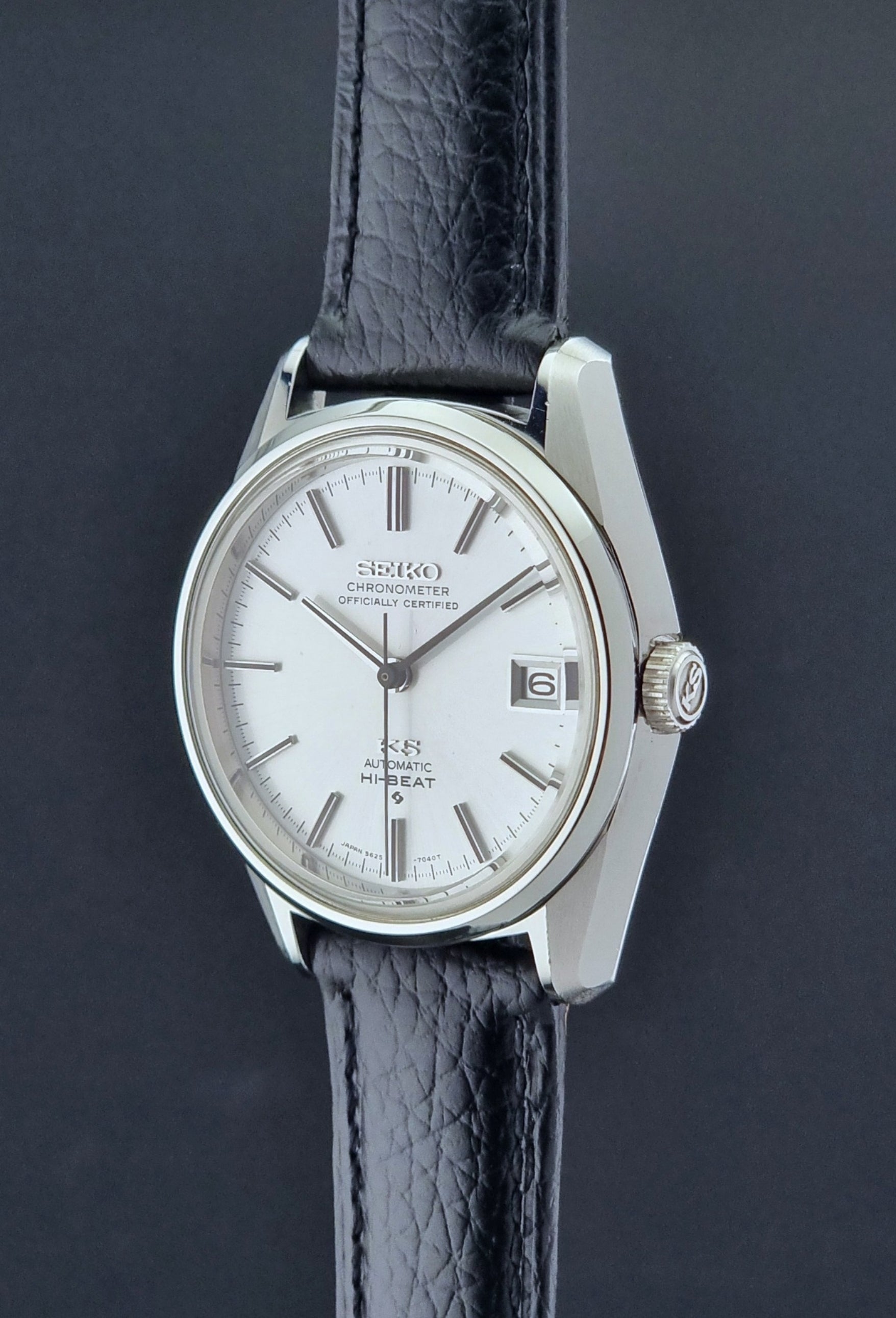 Vintage King Seiko 5625-7040 wrist watch with a black leather strap on a textured dark background crown profile view