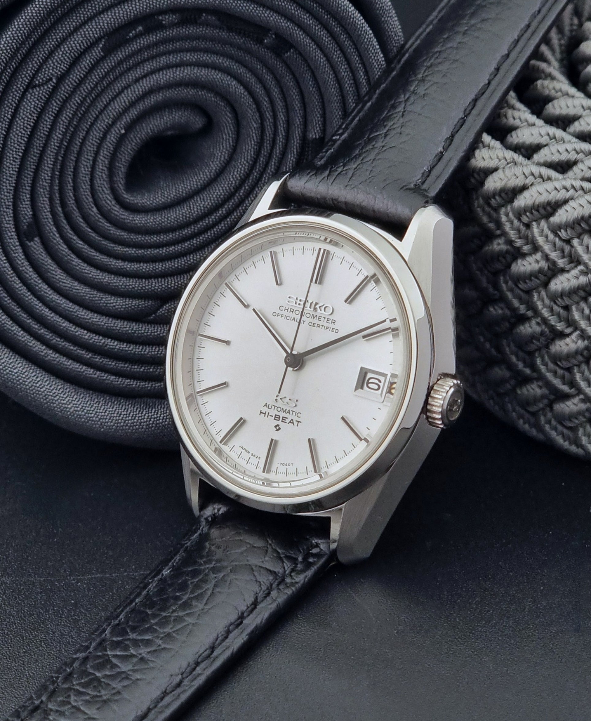 Vintage King Seiko 5625-7040 wrist watch with a black leather strap on a textured dark background crown view