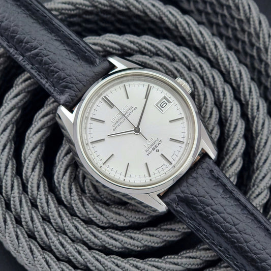 Vintage King Seiko 5625-7040 wrist watch with a black leather strap on a textured dark background front