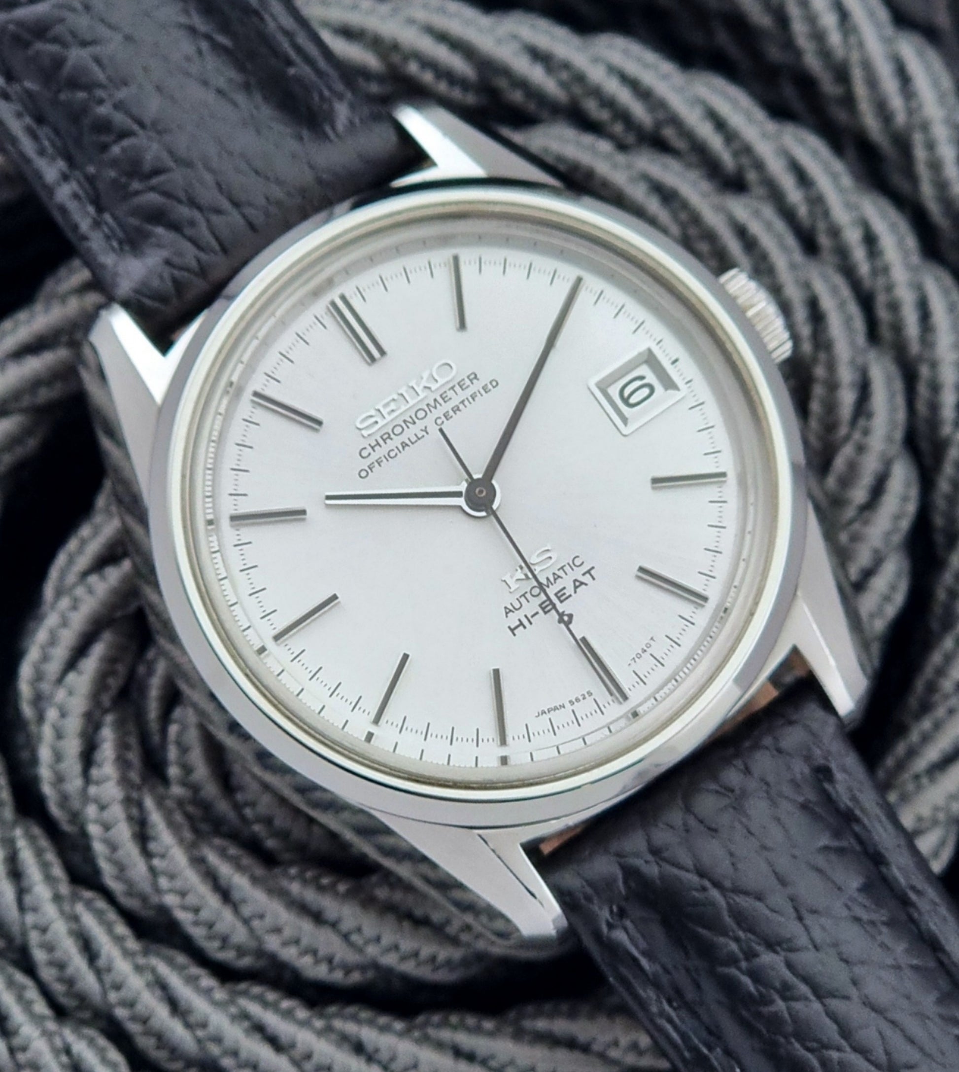 Vintage King Seiko 5625-7040 wrist watch with a black leather strap on a textured dark background dial view