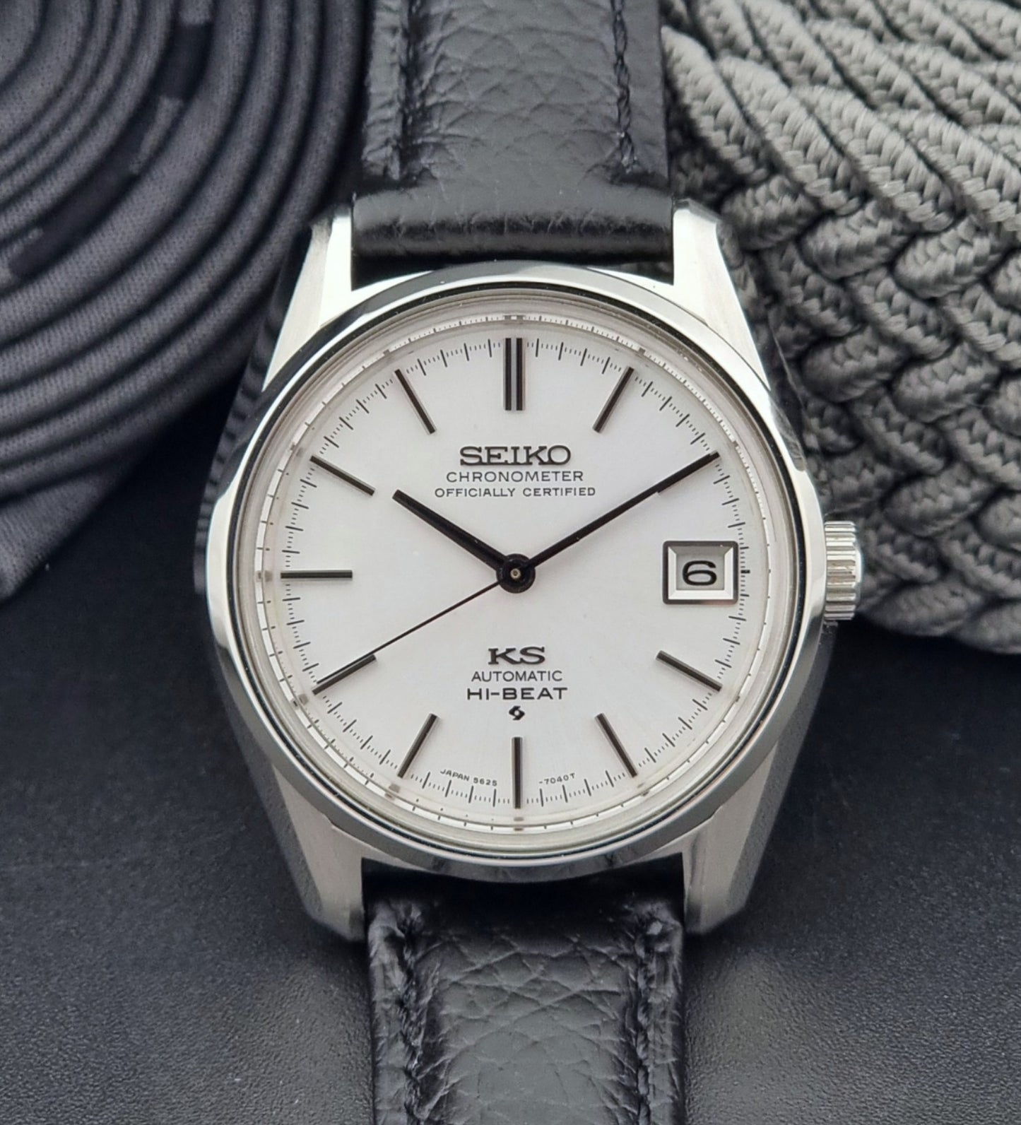 Vintage King Seiko 5625-7040 wrist watch with a black leather strap on a textured dark background close dial view