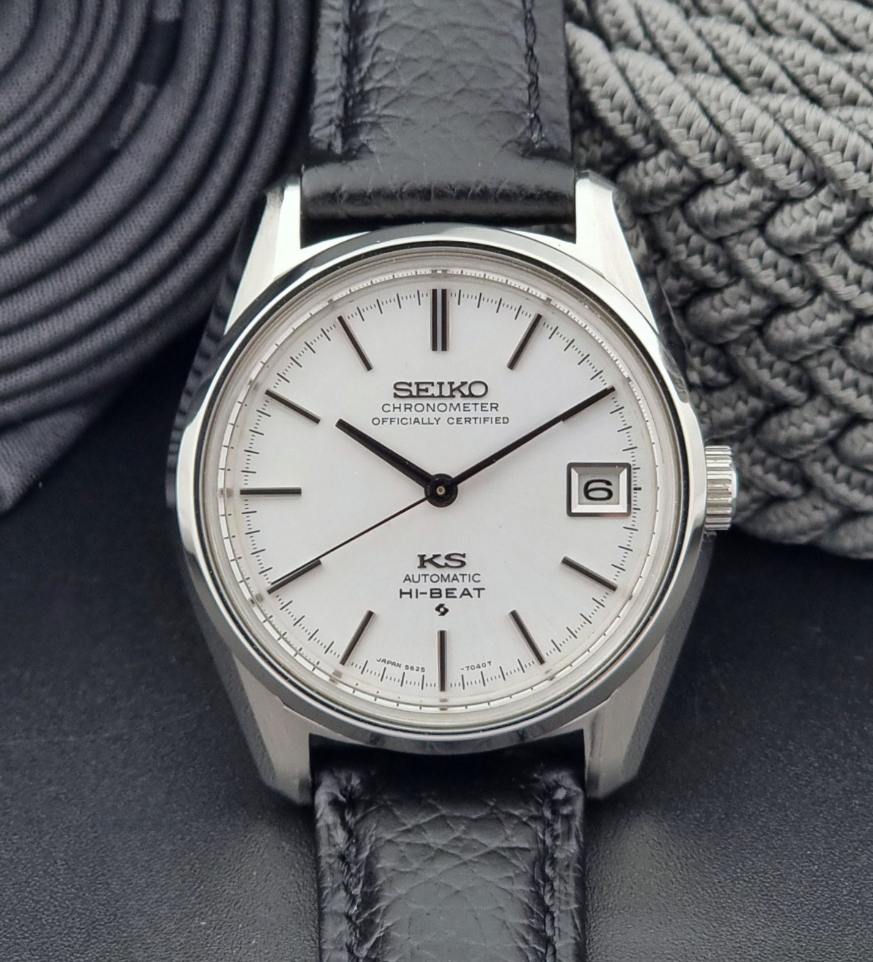 Vintage King Seiko 5625-7040 wrist watch with a black leather strap on a textured dark background close dial view