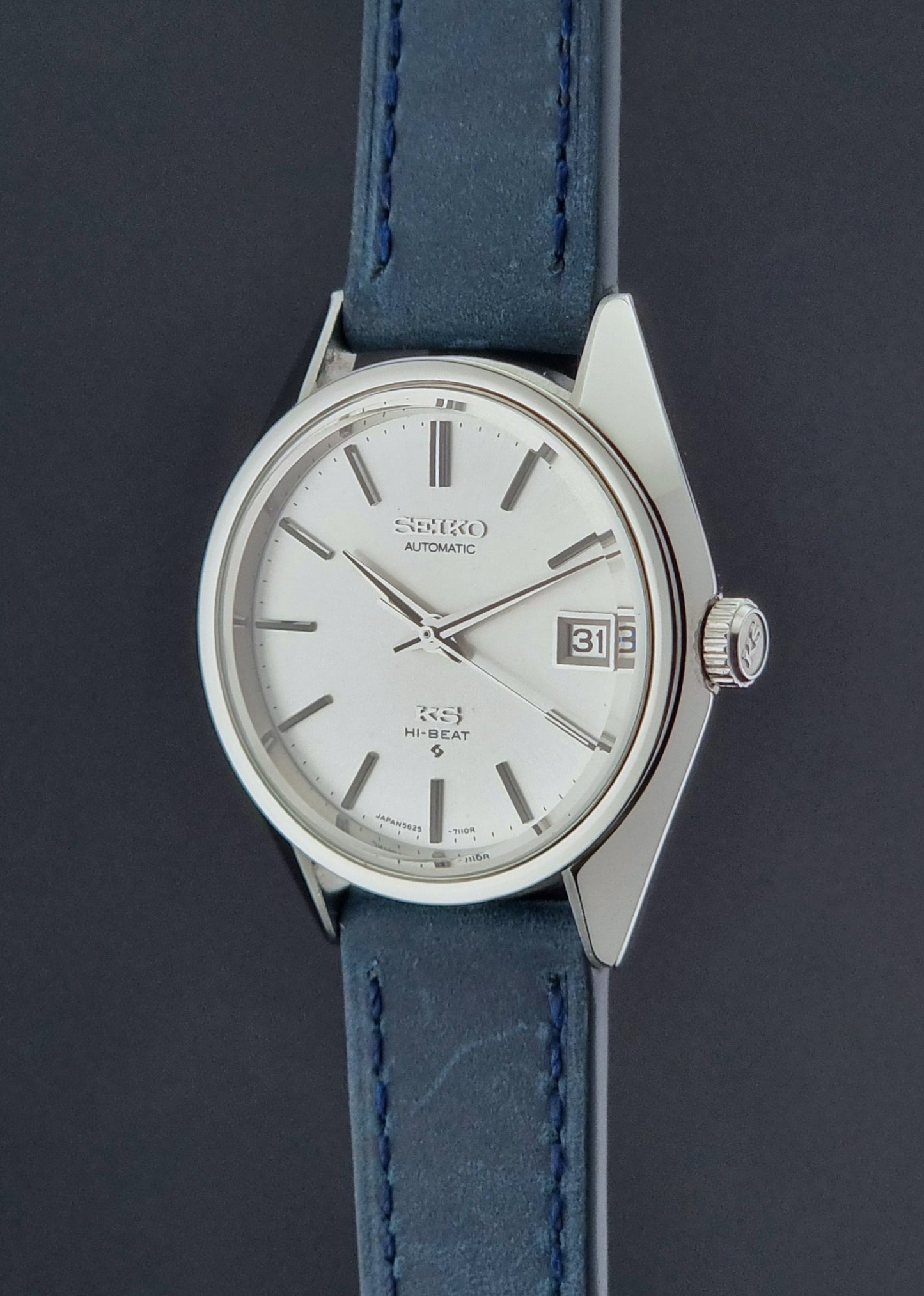 Vintage King Seiko Wristwatch 5625-7110 blue strap and silver case on a dark surface crown profile view