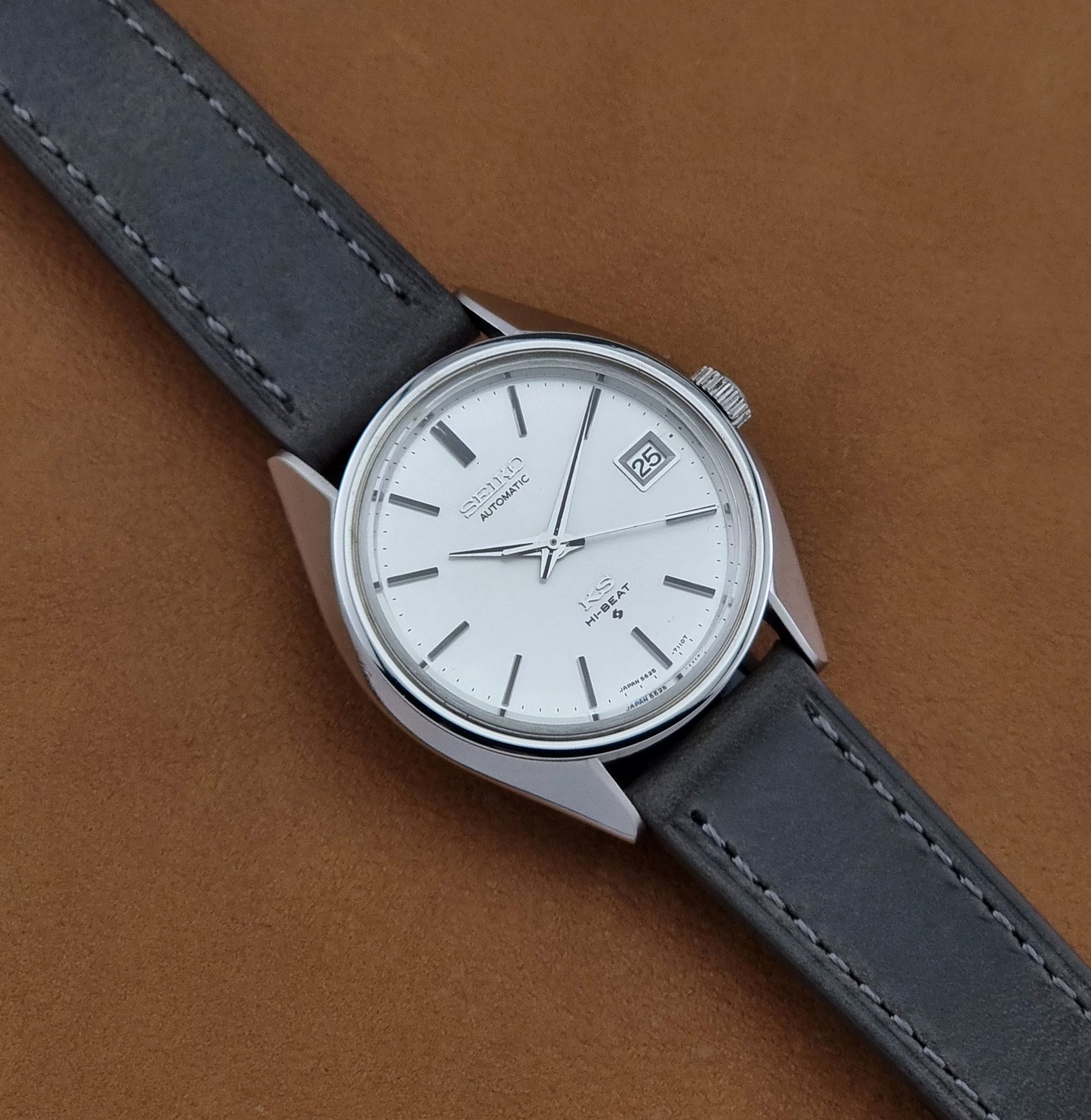 Vintage King Seiko 5625-7110 Wristwatch with a gray strap and white dial on a brown background dial