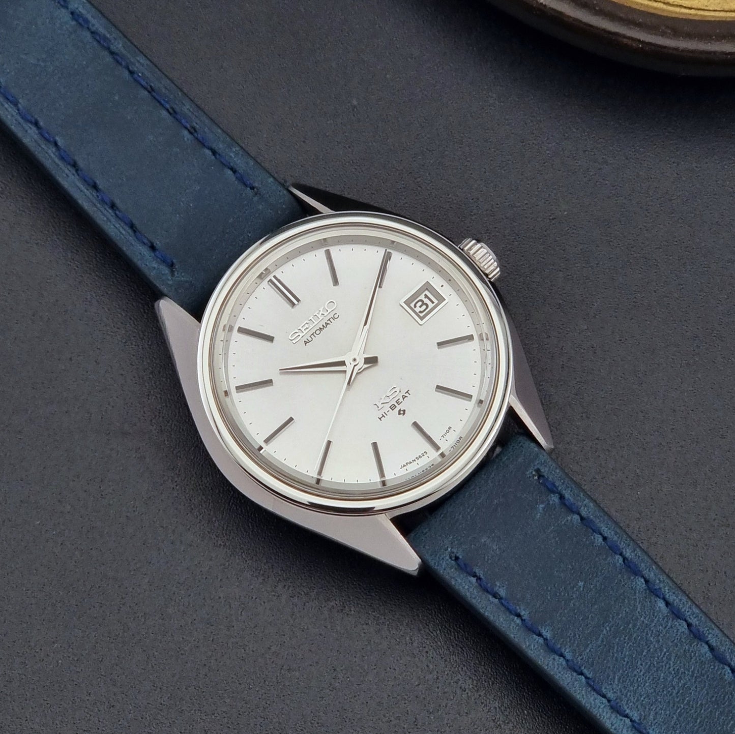 Vintage King Seiko Wristwatch 5625-7110 blue strap and silver case on a dark surface close up dial view