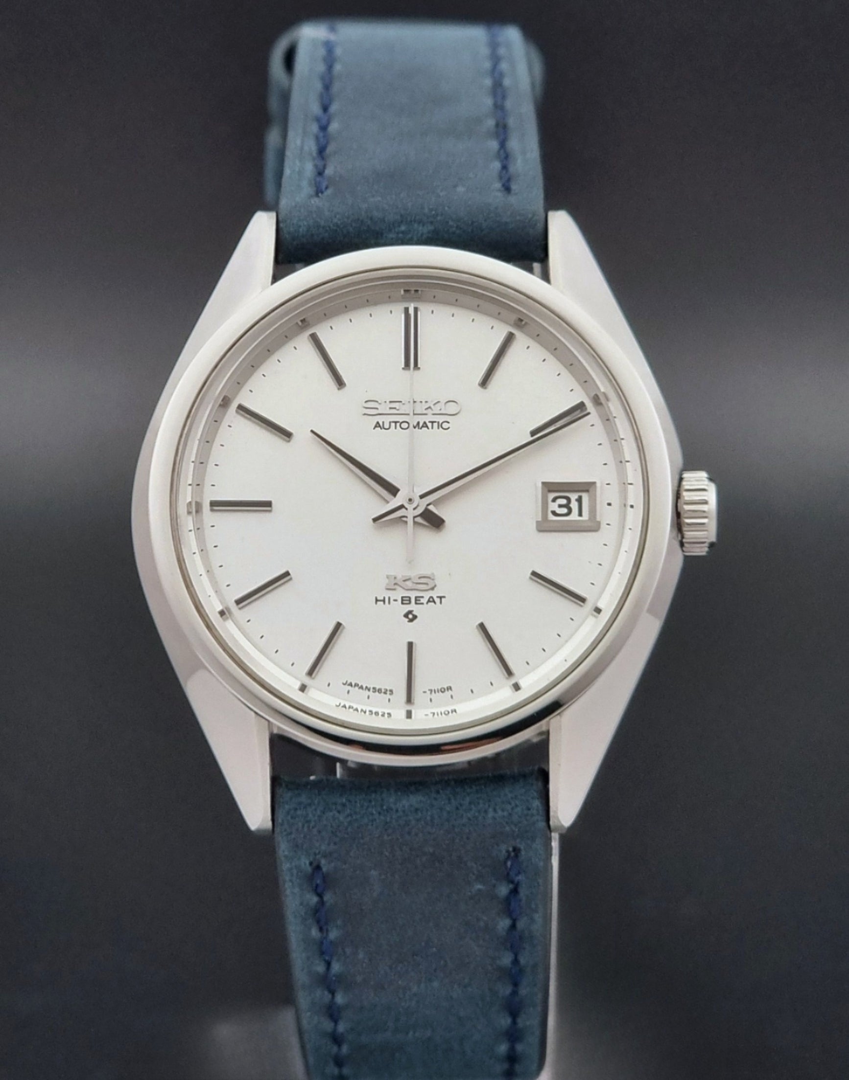 Vintage King Seiko Wristwatch 5625-7110 blue strap and silver case on a dark surface close dial view