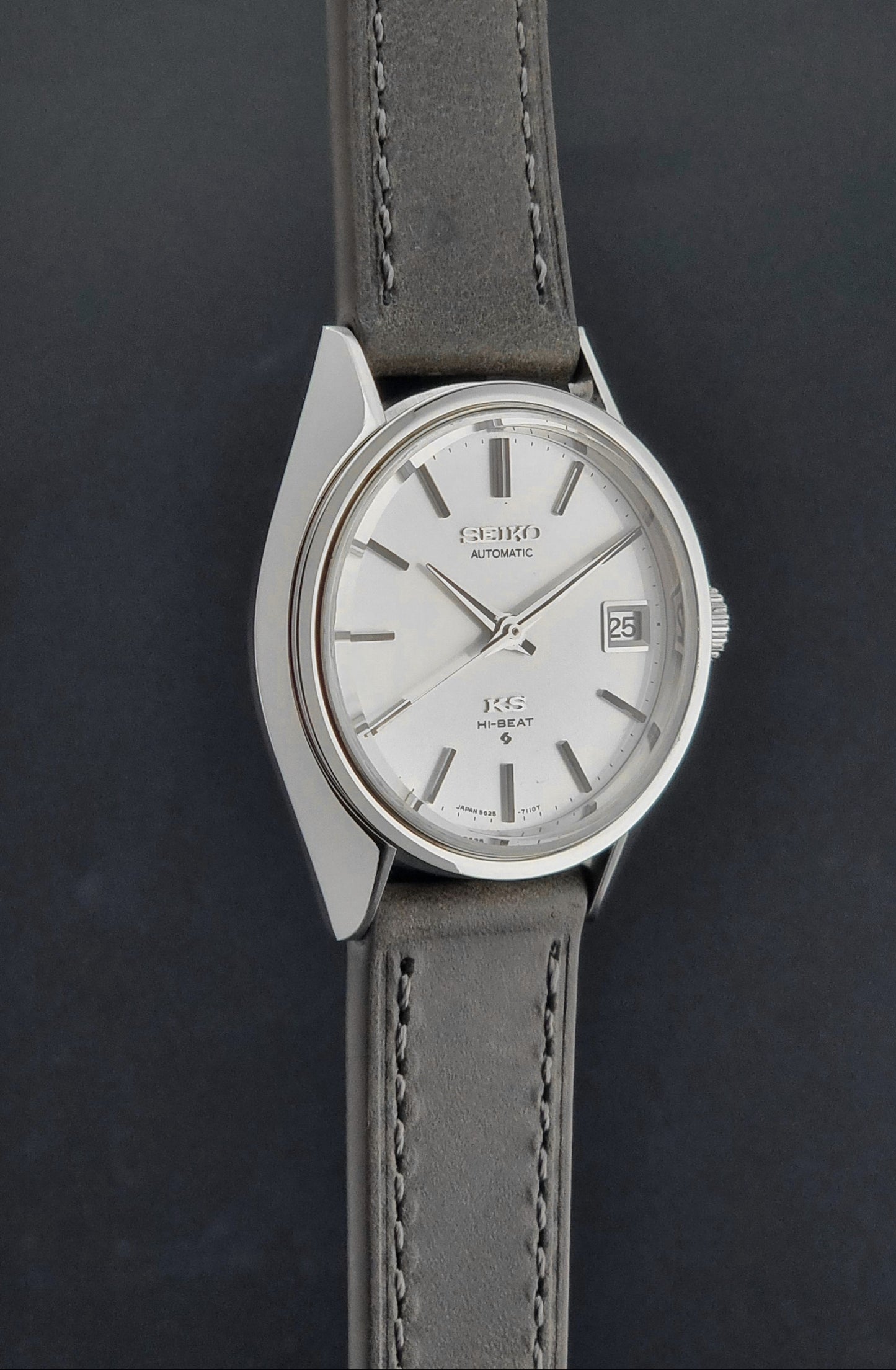Vintage King Seiko 5625-7110 Wristwatch with a gray strap and white dial on a brown background side profile view
