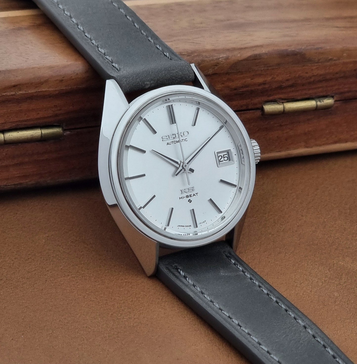 Vintage King Seiko 5625-7110 Wristwatch with a gray strap and white dial on a brown background side view