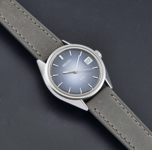 Vintage King Seiko 5625-7111 watch with a silver-toned metal case, a blue dial, and a taupe leather strap, shown on a dark gray background dial