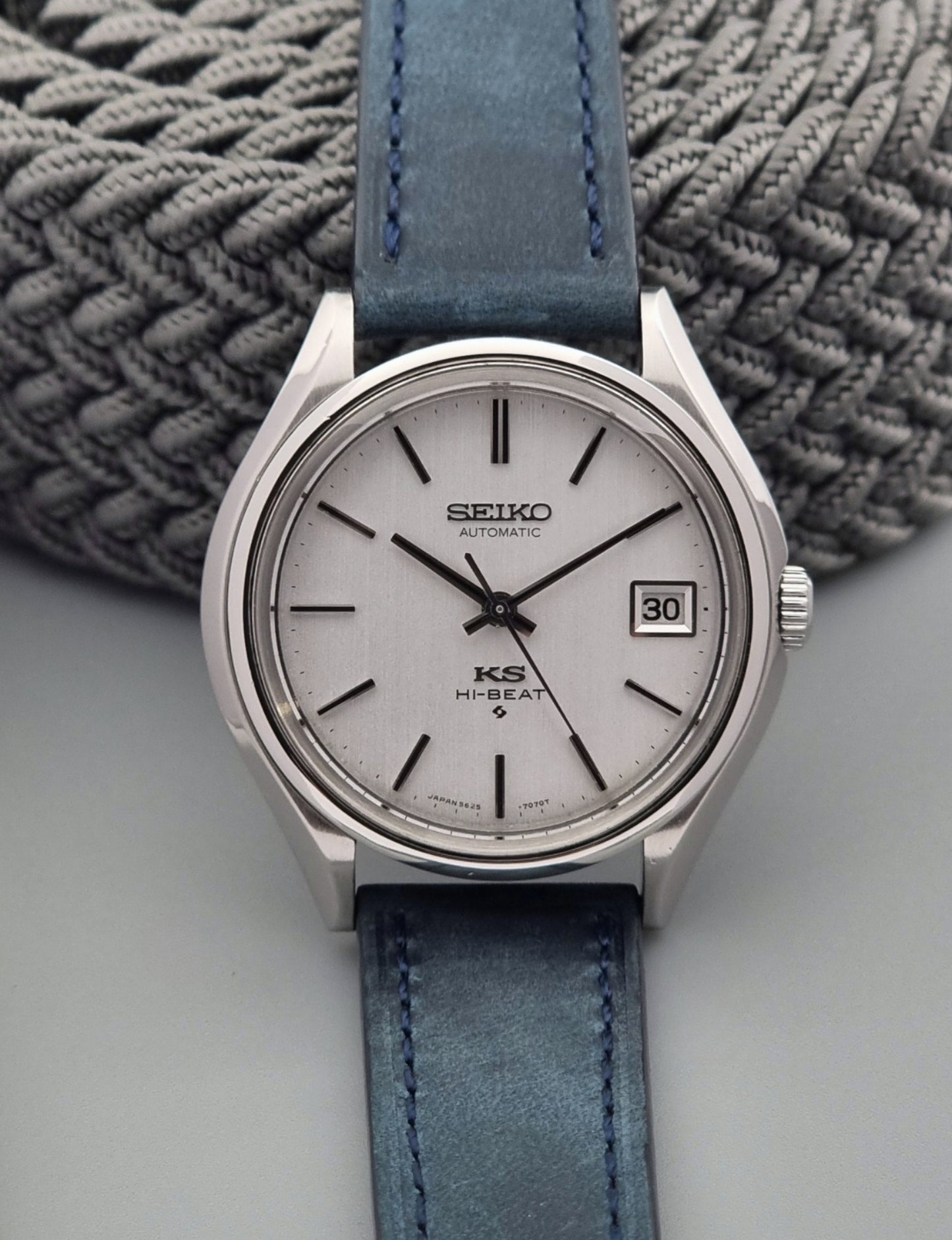 Vintage King Seiko watch with blue strap on a textured surface