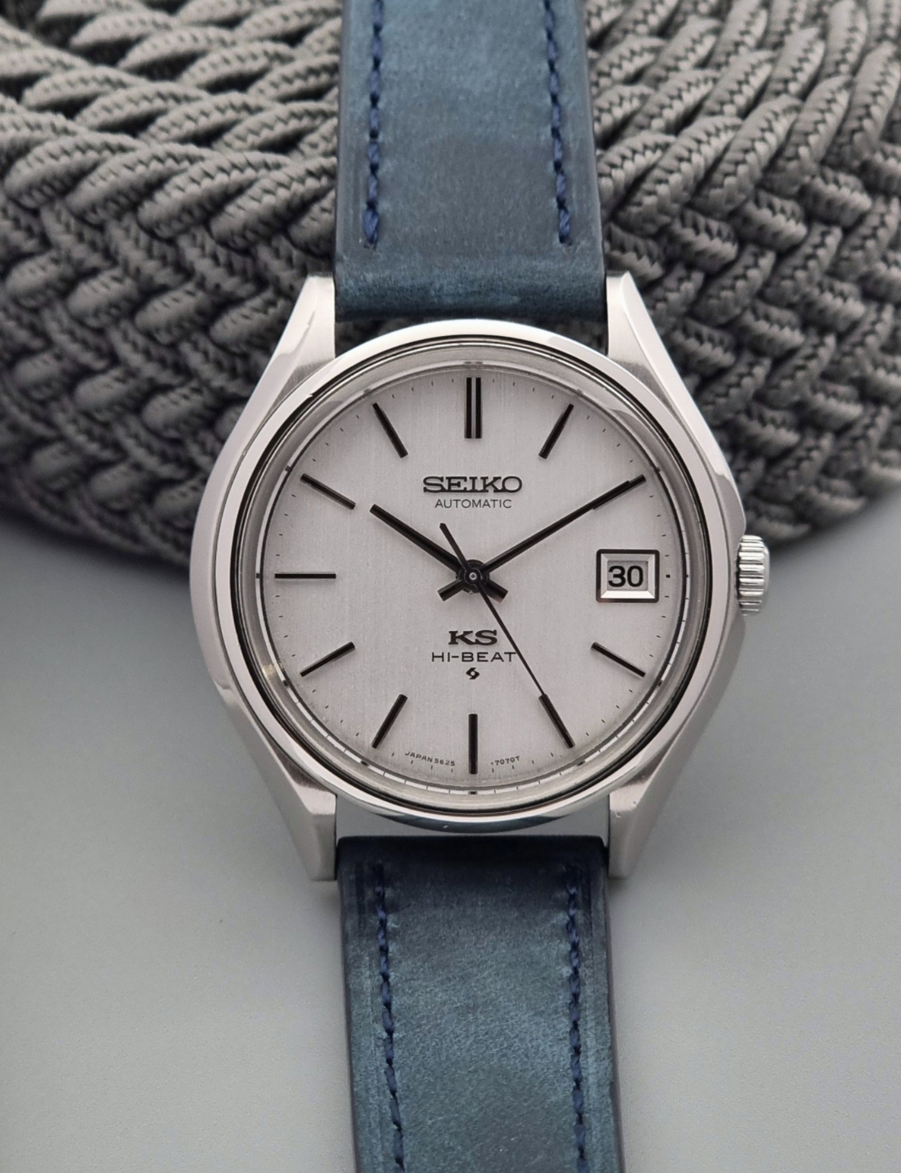 Vintage King Seiko watch with blue strap on a textured surface