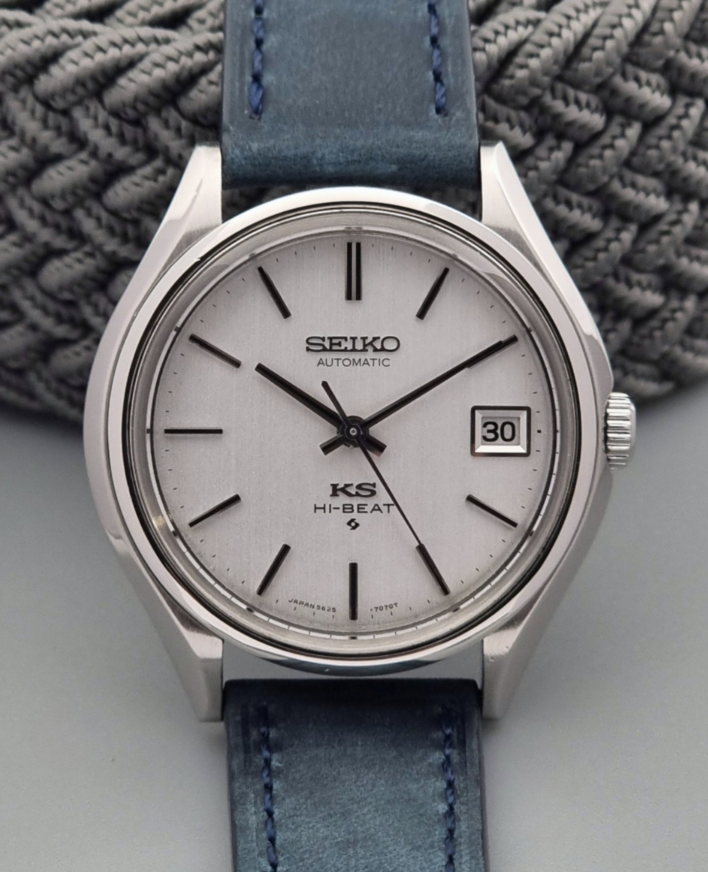 Vintage King Seiko watch with blue strap on a textured surface