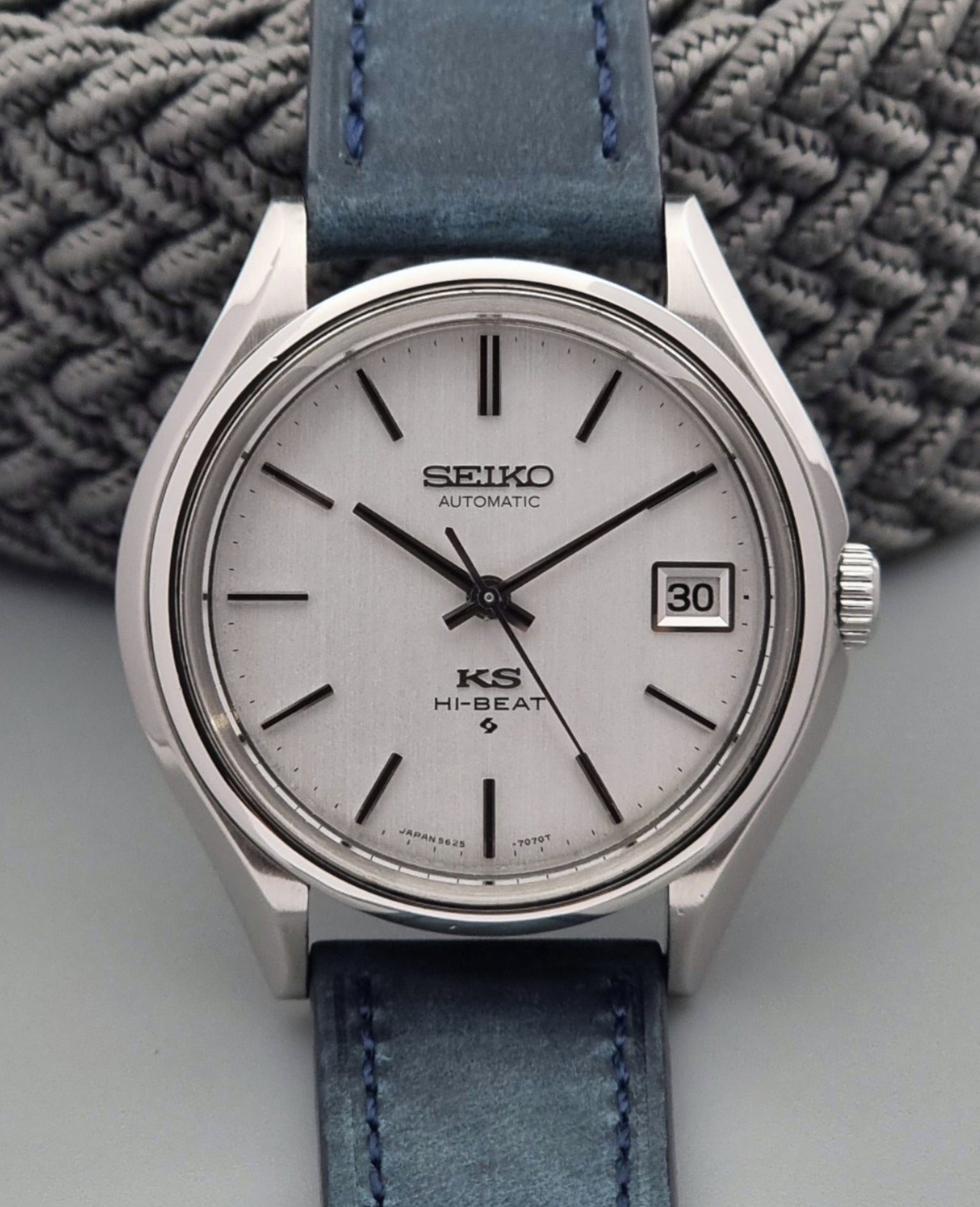 Vintage King Seiko watch with blue strap on a textured surface