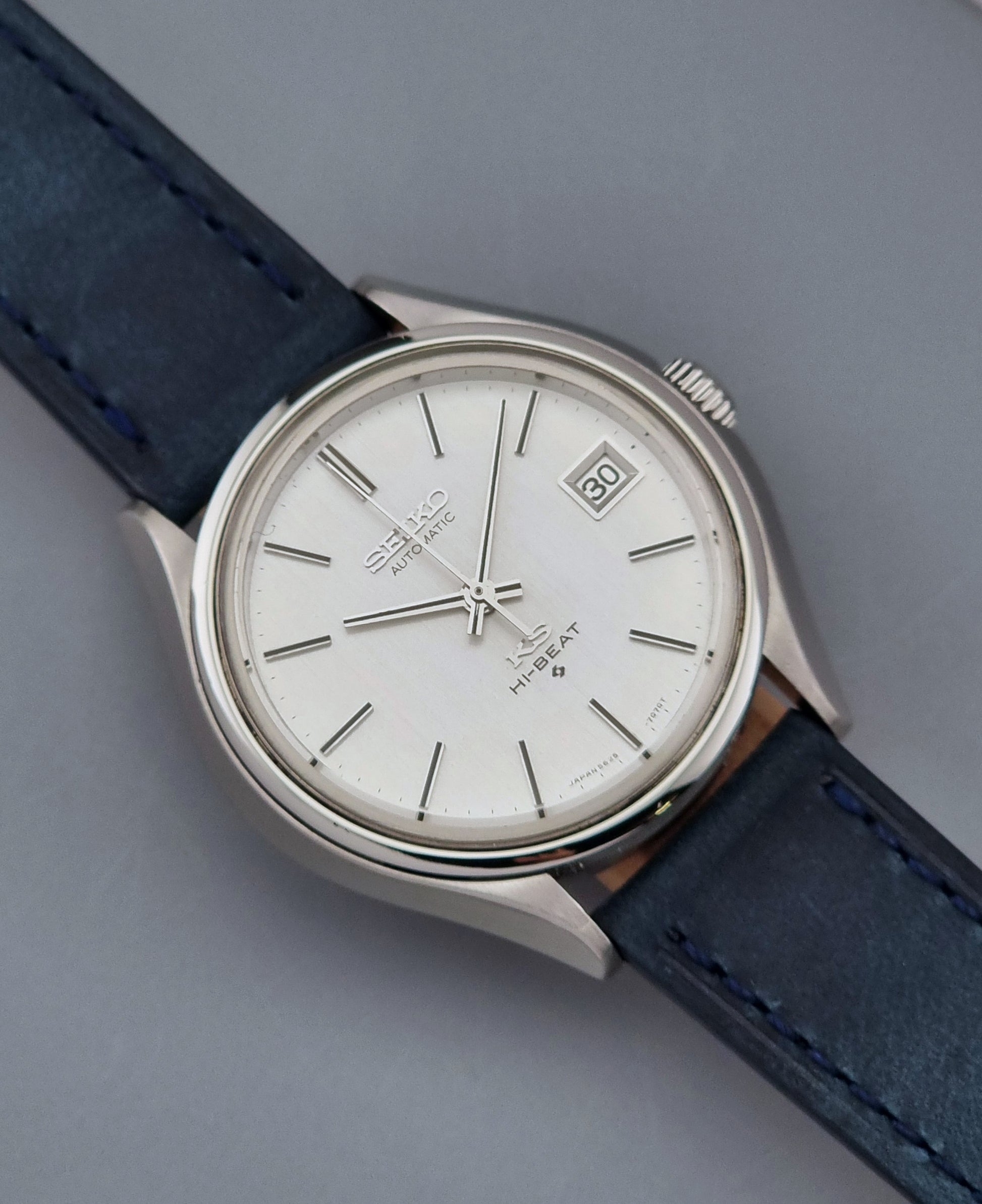Vintage King Seiko watch with blue leather strap on a gray background