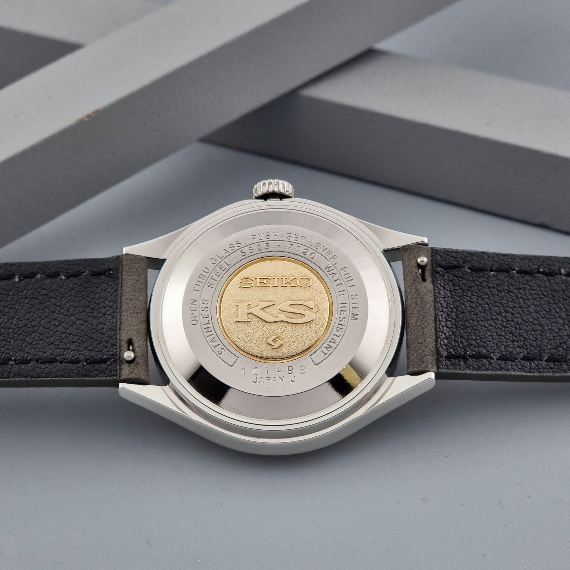 Vintage King Seiko watch 5625-7120 with a grey leather strap on a grey background case back view