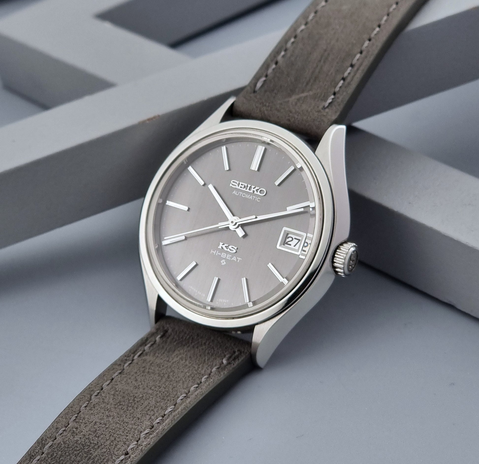 Vintage King Seiko watch 5625-7120 with a grey leather strap on a grey background crown view