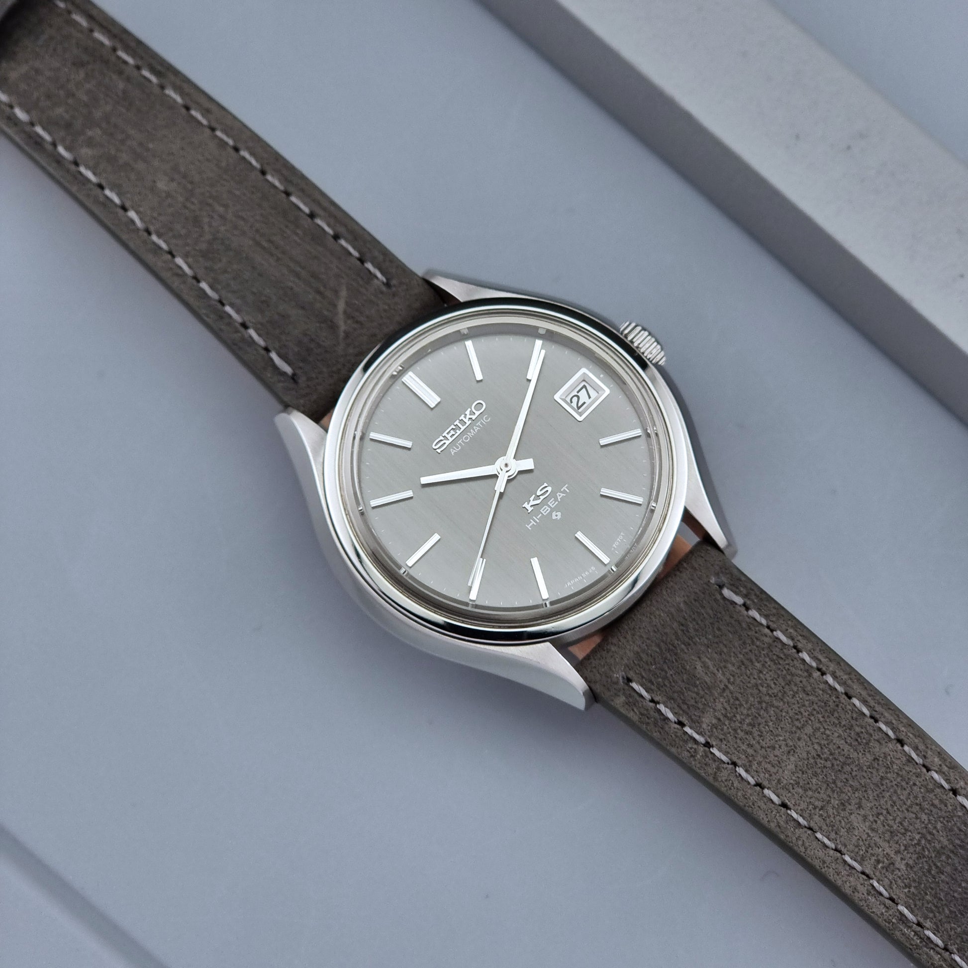 Vintage King Seiko watch 5625-7120 with a grey leather strap on a grey background