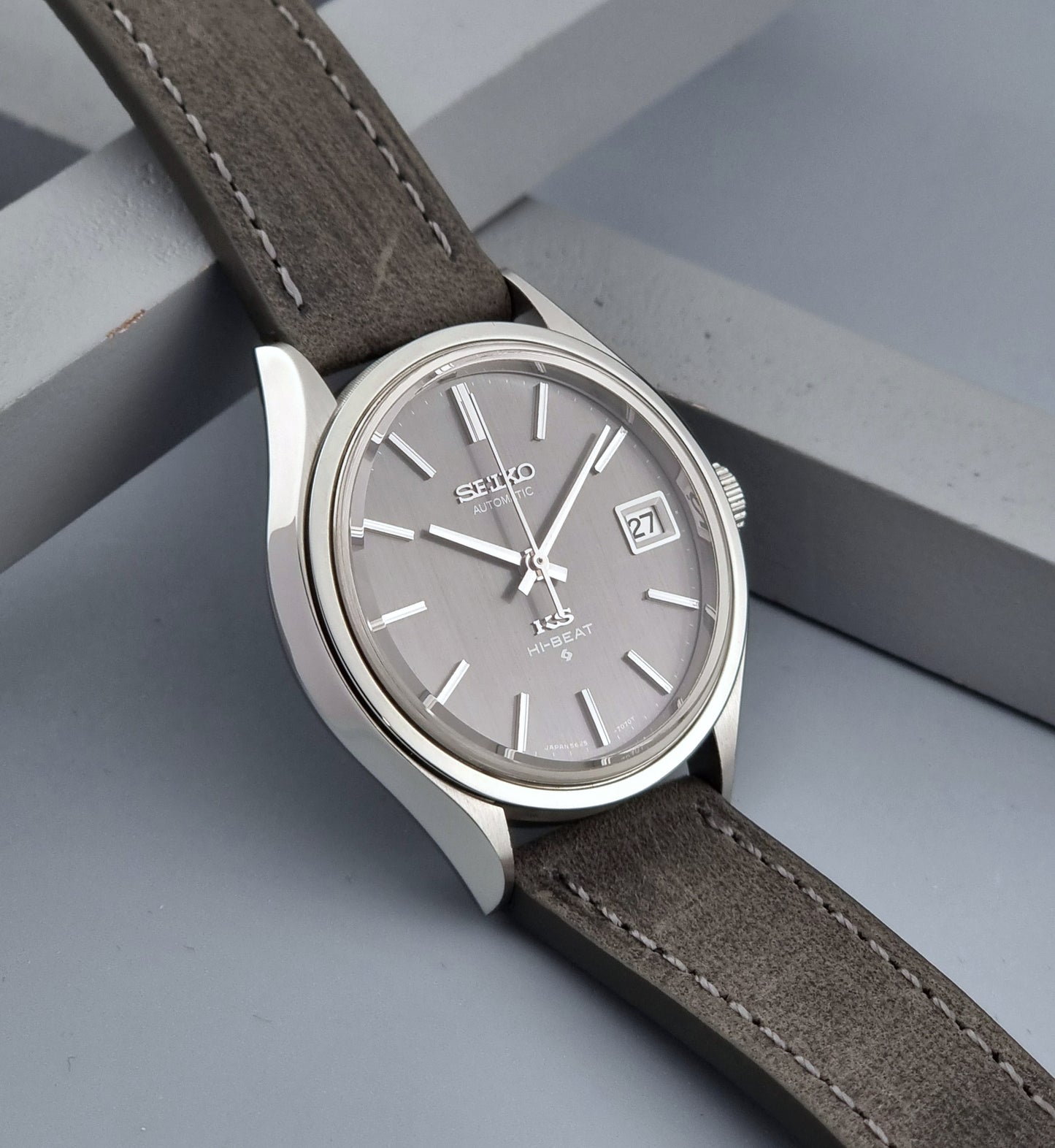 Vintage King Seiko watch 5625-7120 with a grey leather strap on a grey background side view