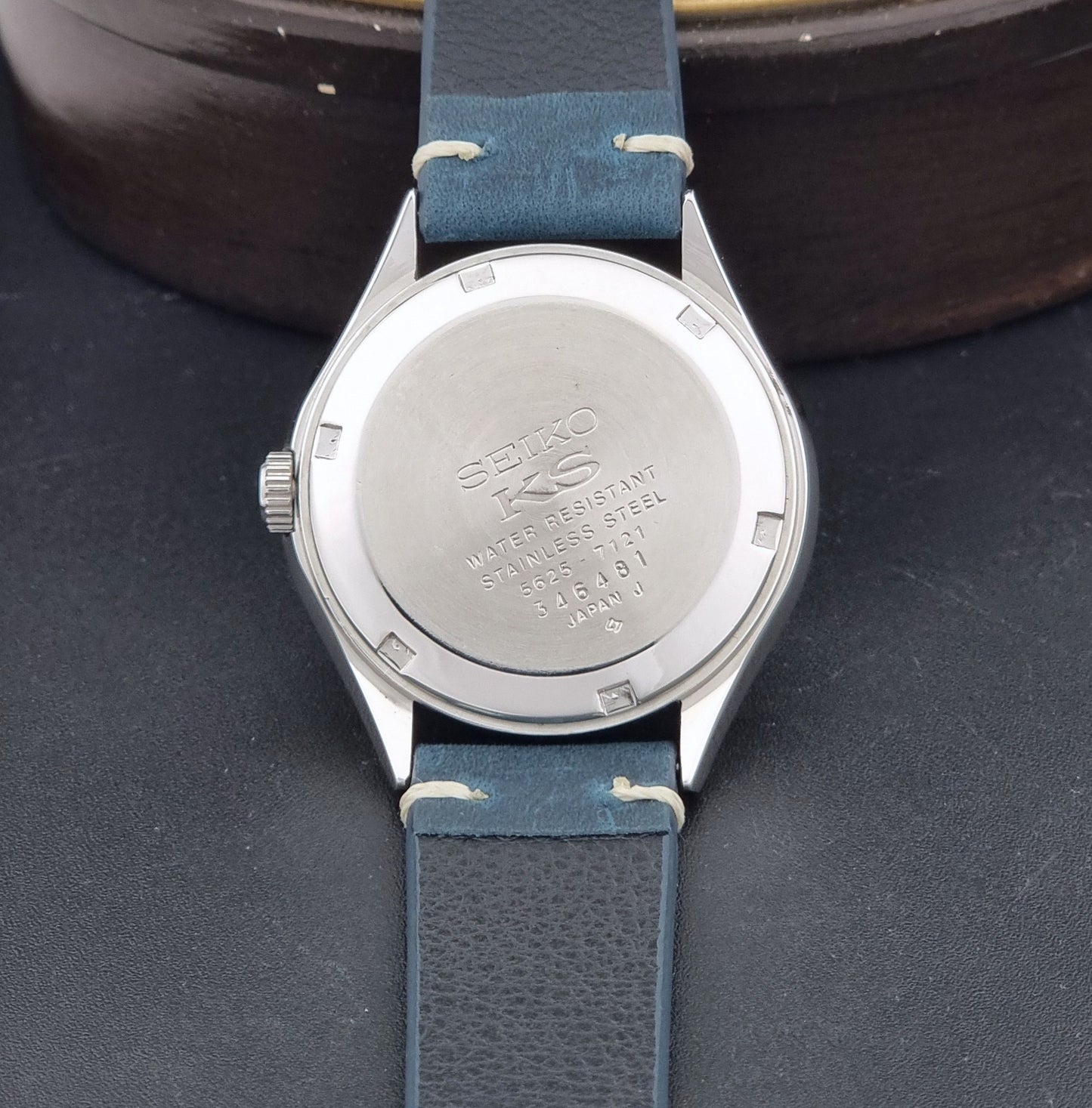 Vintage King Seiko 5625-7121 watch with blue strap on a dark gray background case back view