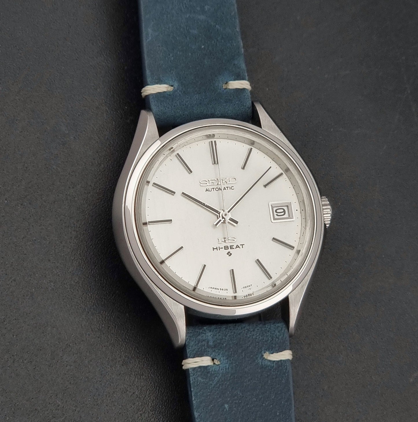 Vintage King Seiko 5625-7121 watch with blue strap on a dark gray background front view